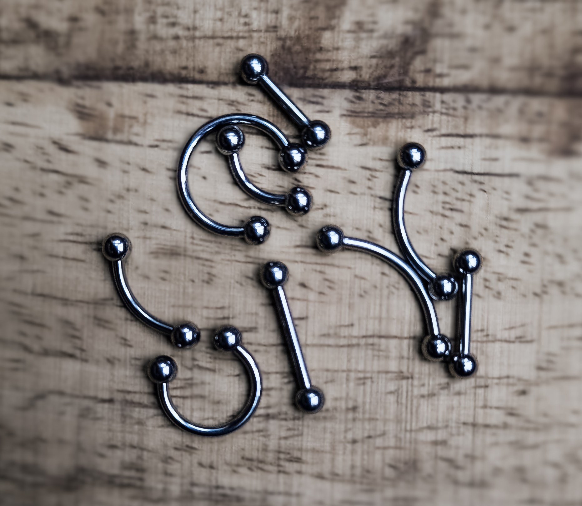 A collection of surgical-grade titanium piercing barbels - horseshoes, microbars and curved barbels in 16g and various lengths to suit multiple body piercing placements