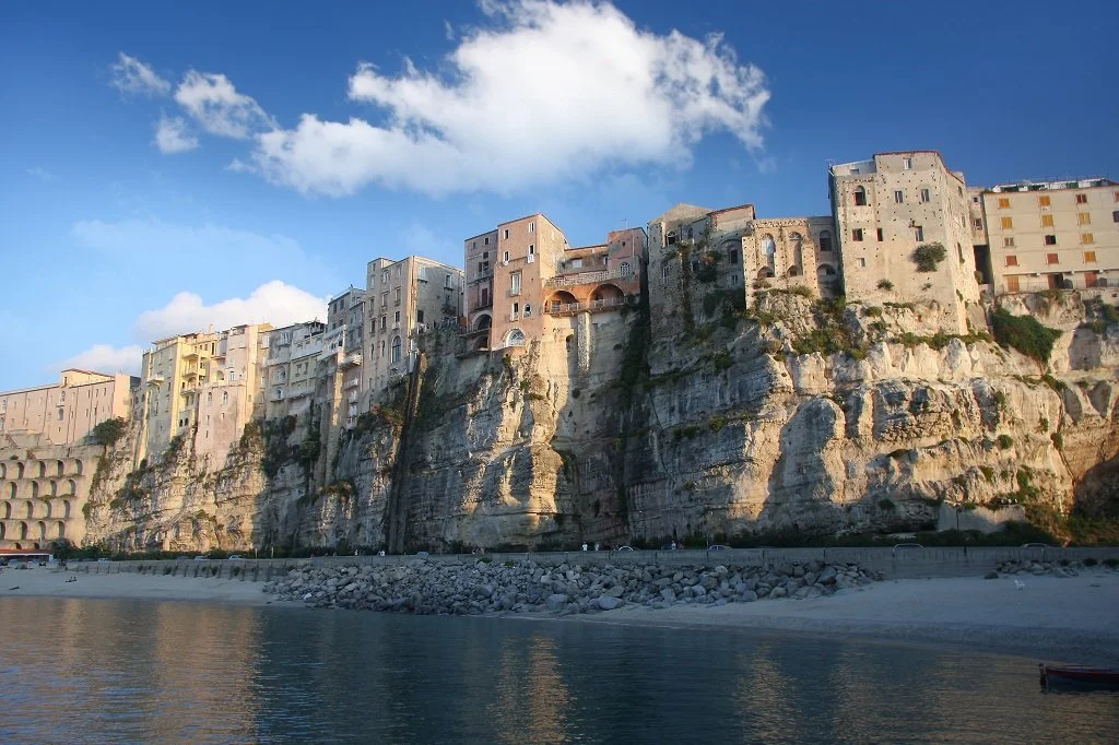 Colorful buildings built on a steep hillside overlooking the water.
