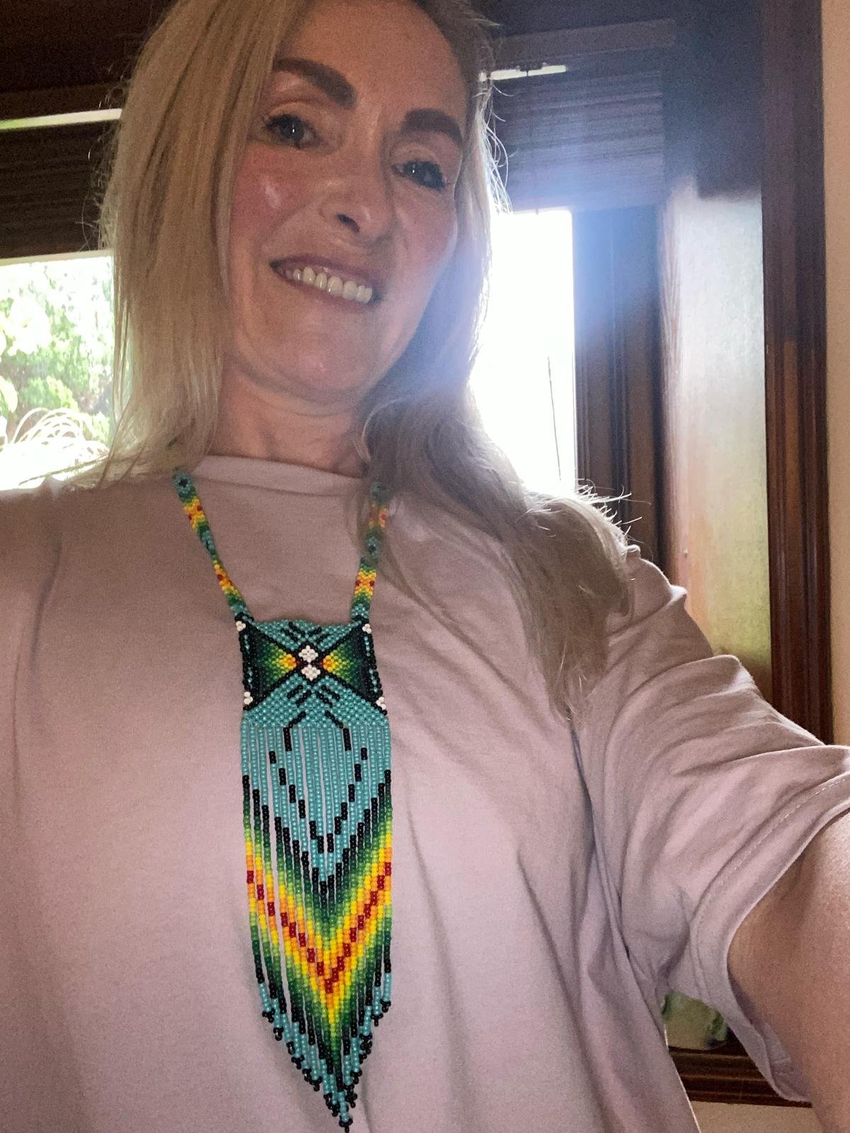 Person wearing a colorful beaded necklace.