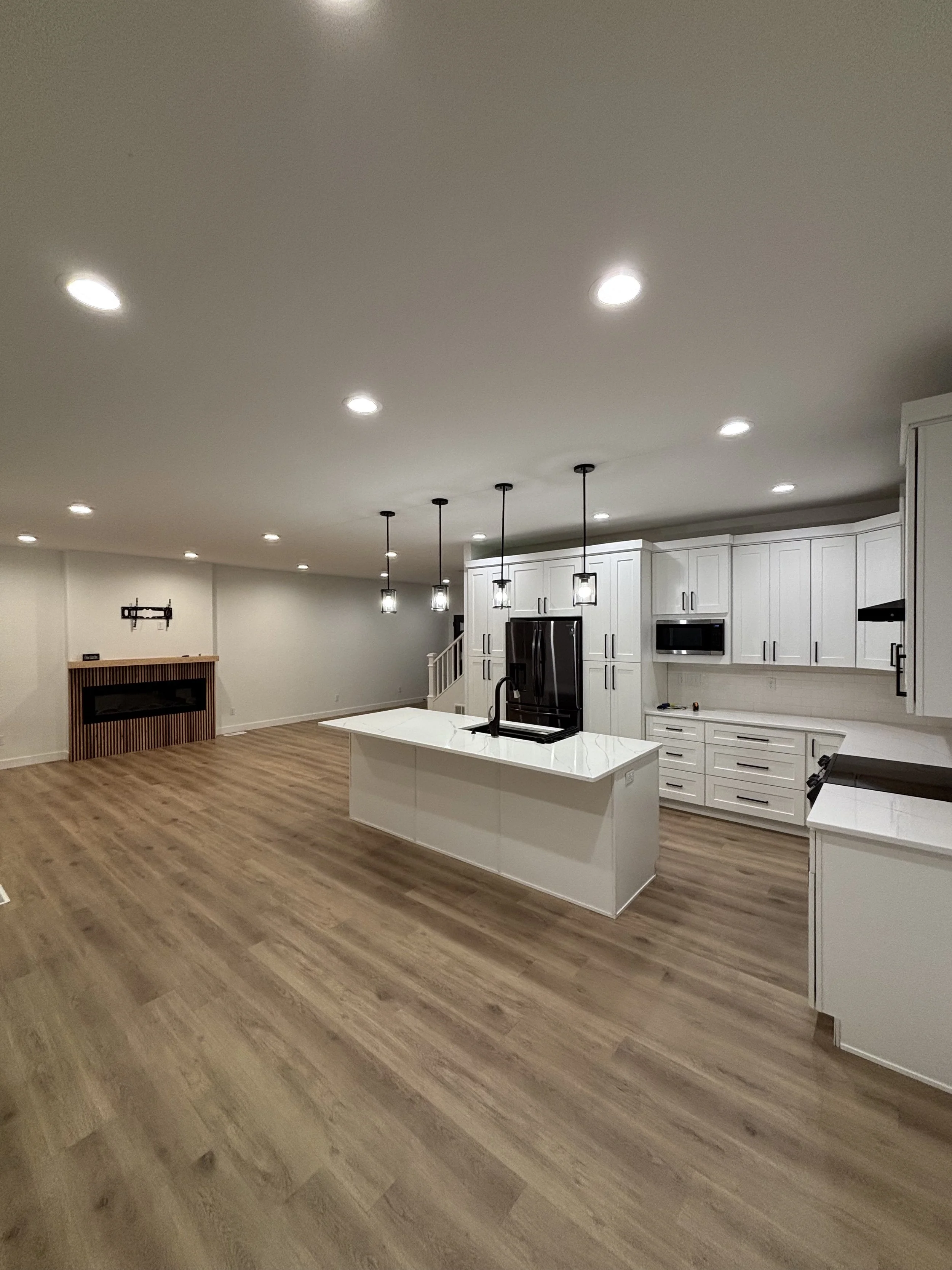 Photo of a clean kitchen and living room of a residential home