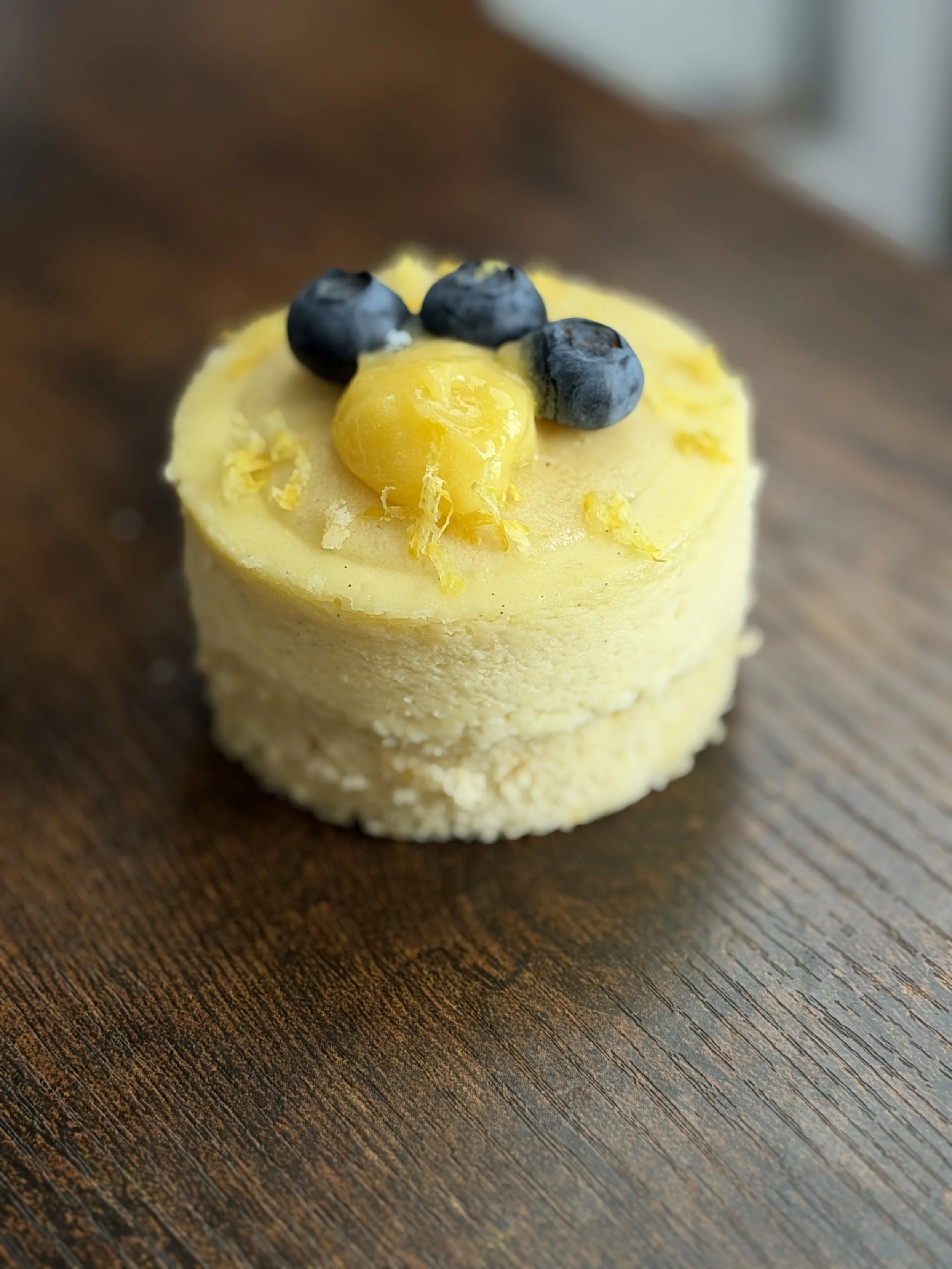 Individual Tall Lemon Cake Cheesecake.  Finished Lemon Curd, Fresh Blueberries, and Lemon Zest garnish.