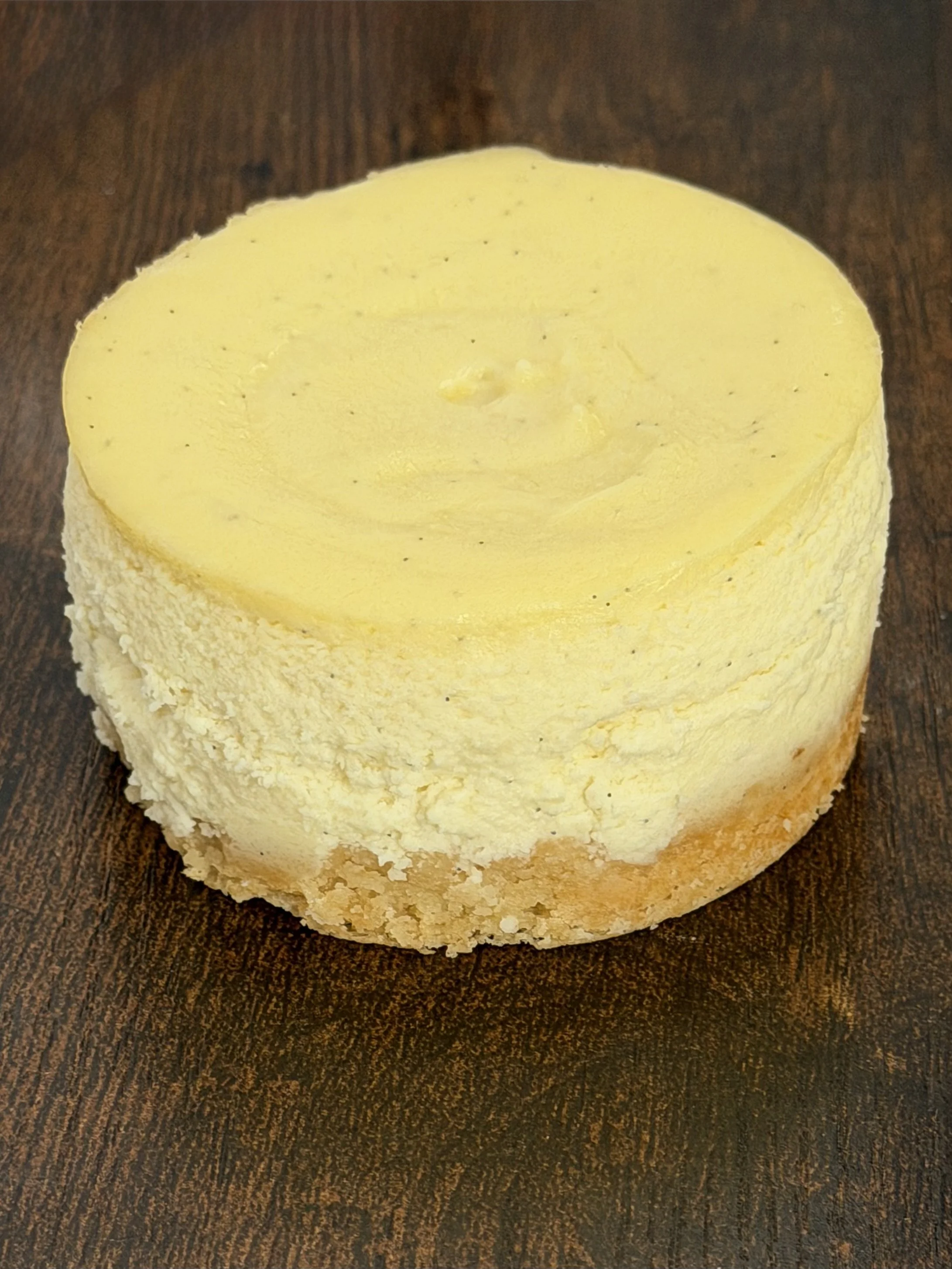 Vanilla Bean NY Style Cheesecake.  A classic New York-Style cheesecake crafted with real vanilla bean and baked in a buttery vanilla cookie crust.  Smooth, dense, and delicately balanced for a rich yet clean finish.
