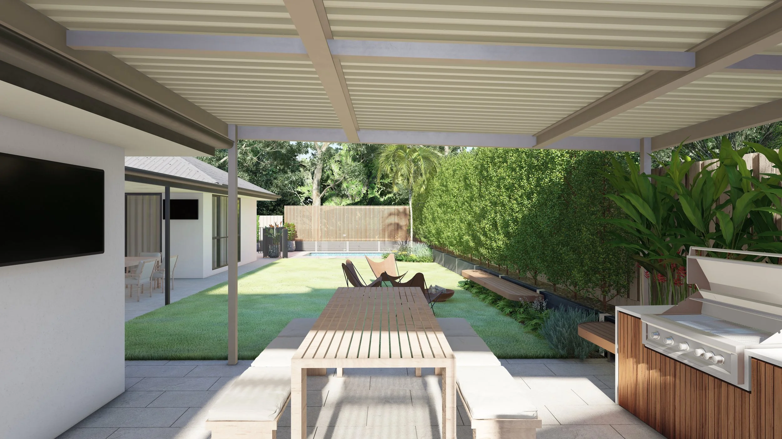 Covered outdoor patio area with a dining table and benches, a barbecue grill, and a view of a lush green backyard with a lawn, bench, and fencing.