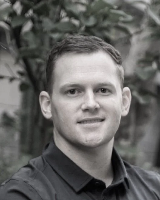 Professional headshot of Jason O'Toole, landscape design and construction specialist in Brisbane, Australia, standing outdoors with a garden backdrop.