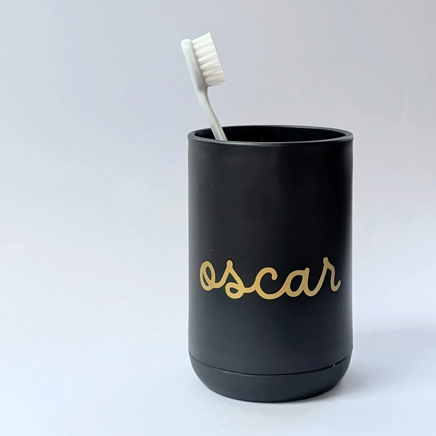 Keep your kid's bathroom routine fun and organized with our shatterproof, customizable toothbrush cups! 🌟 Available in a gorgeous assortment of classy colors, this sleek black cup with metallic gold personalization was made for Oscar. Perfect for li