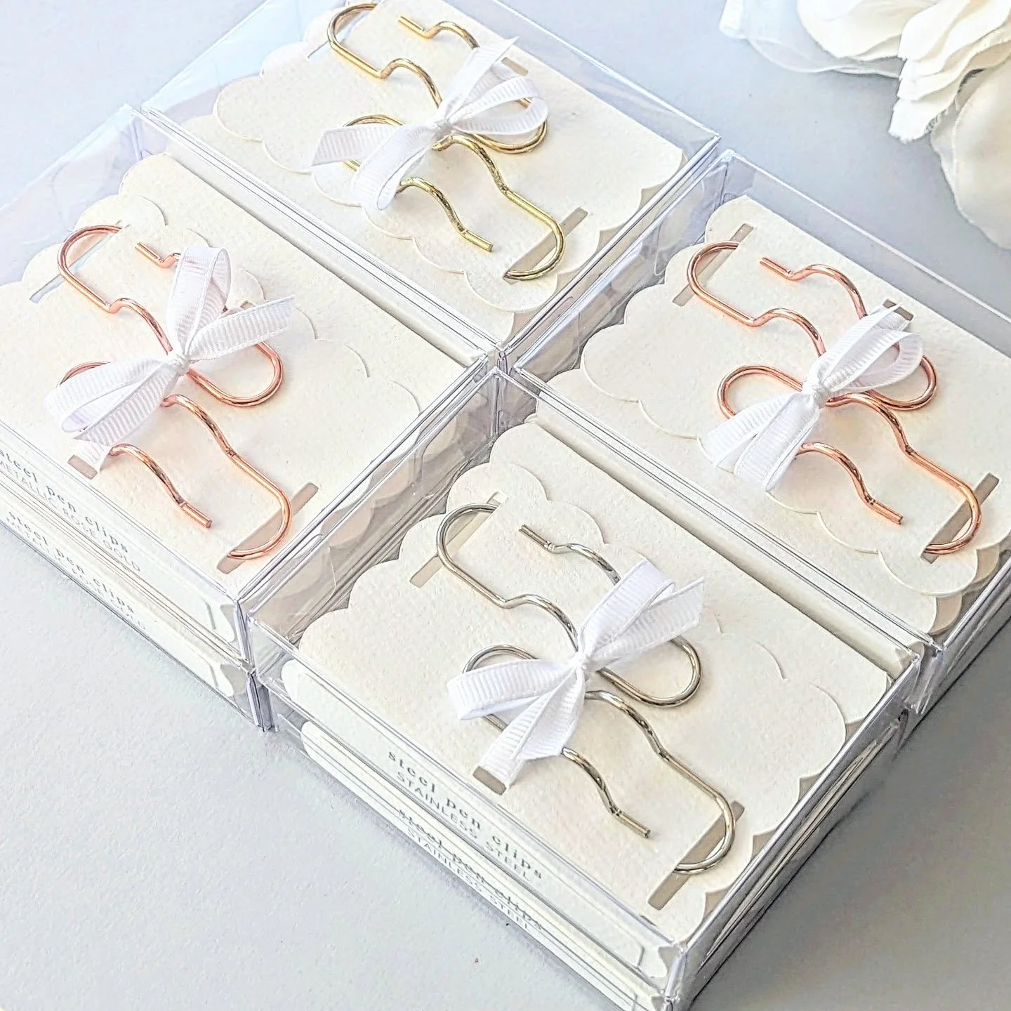 Elevate her everyday with quiet luxury ✨ These metallic gold, rose gold, and steel pen clips arrive gift-ready in a crystal-clear box, nestled in scalloped textured paper and finished with a hand-tied bow. Timeless sophistication for the desk that co