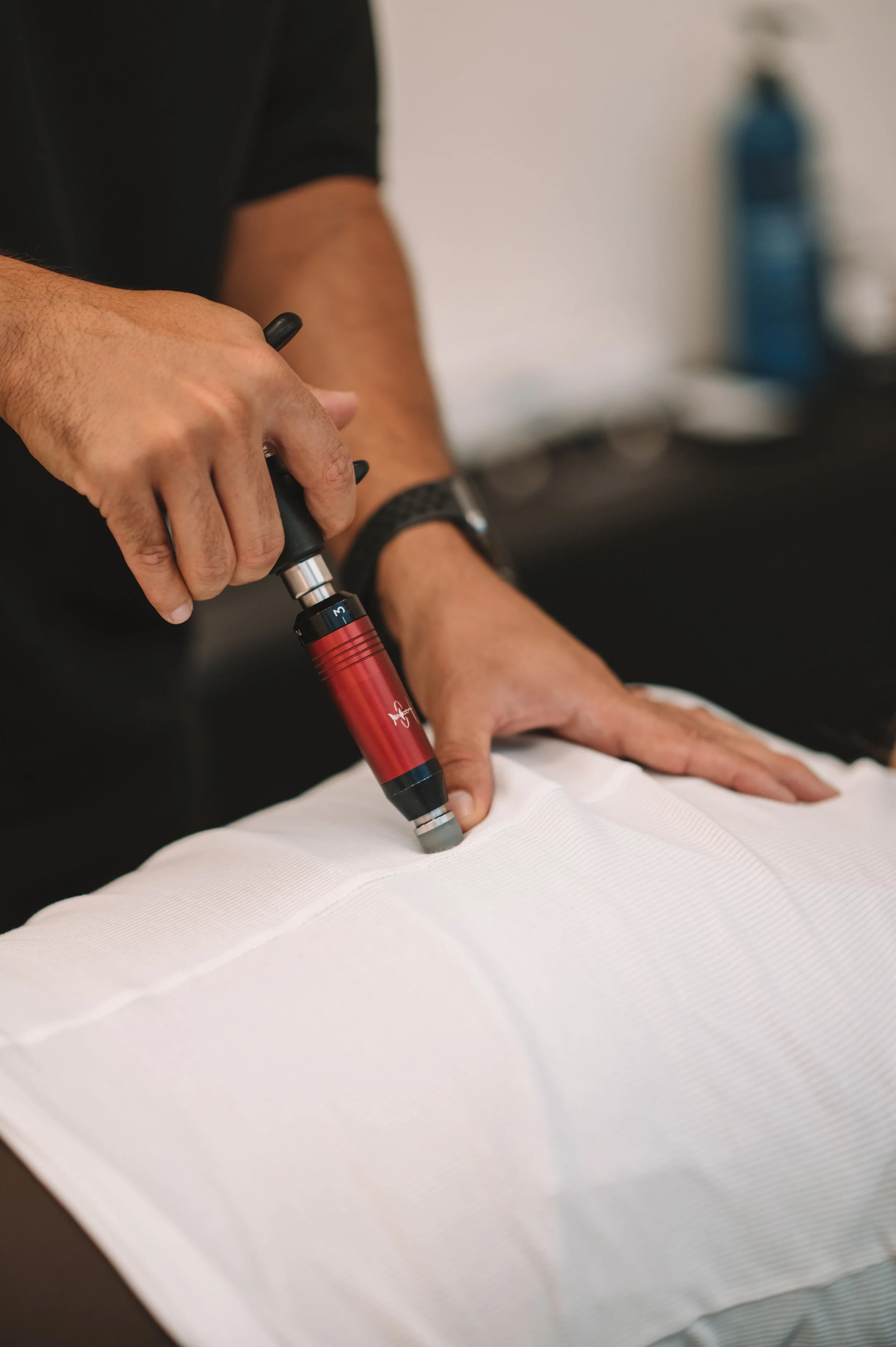 A Chiropractor using an activator on a client
