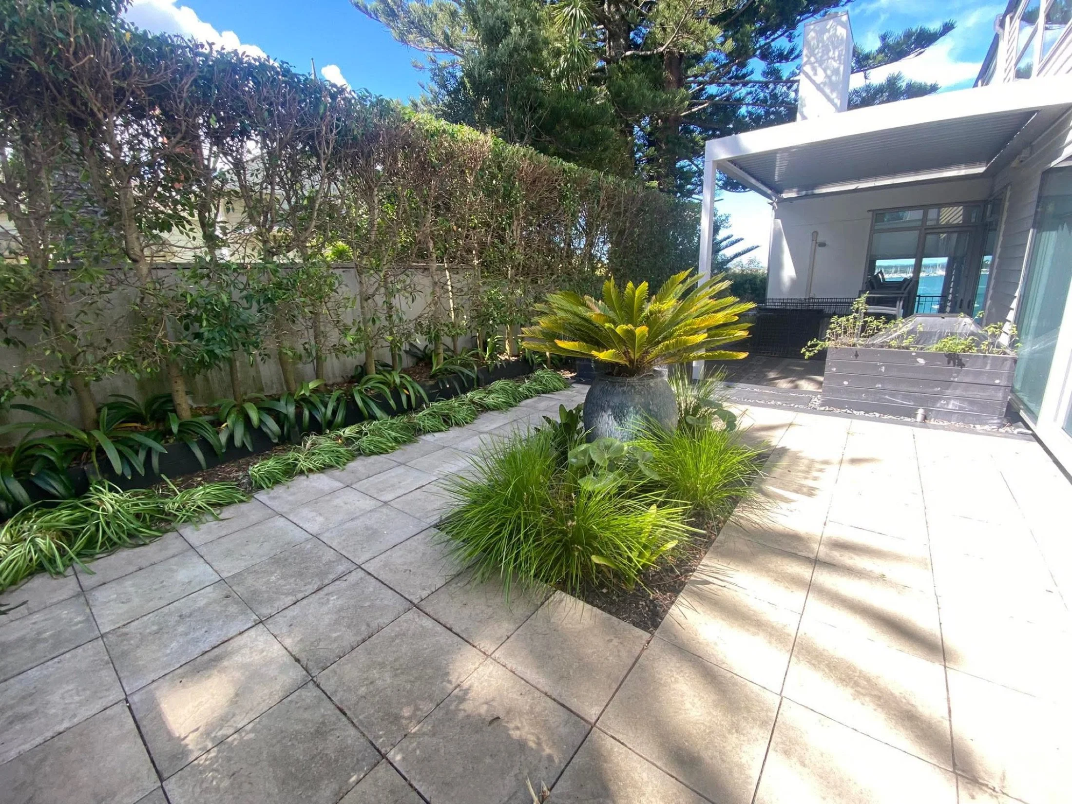 Paved courtyard and garden hardscaping by Pacific Roots Landscaping