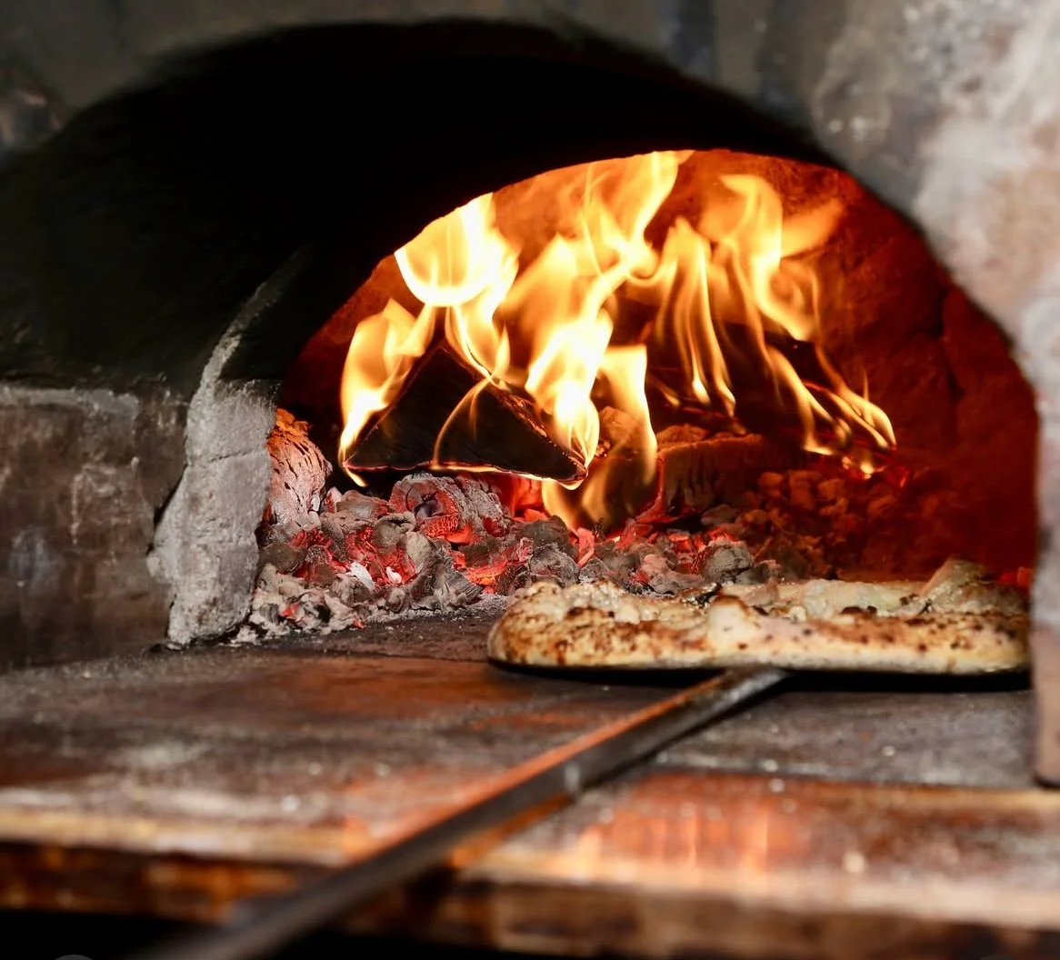 Wood fired pizza cooking in food truck oven