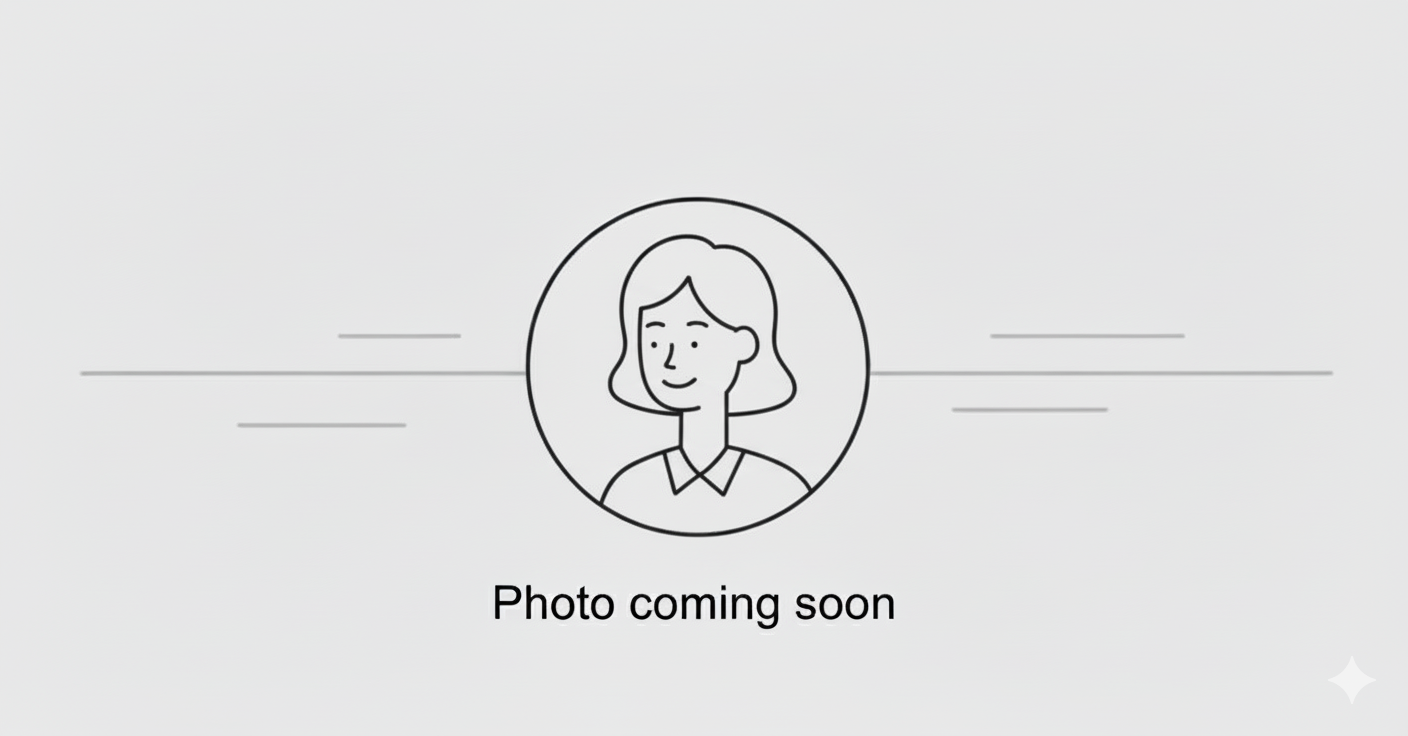 Placeholder image with an illustration of a woman with shoulder-length hair, wearing a collared shirt, and smiling. Text below reads "Photo coming soon."