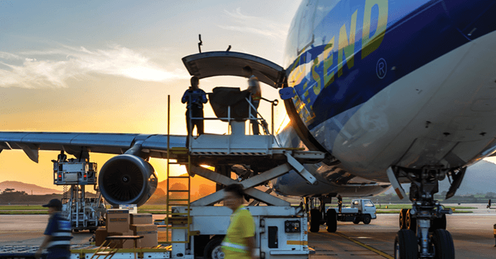 People boarding a Southwest Airlines plane at an airport gate during sunset.