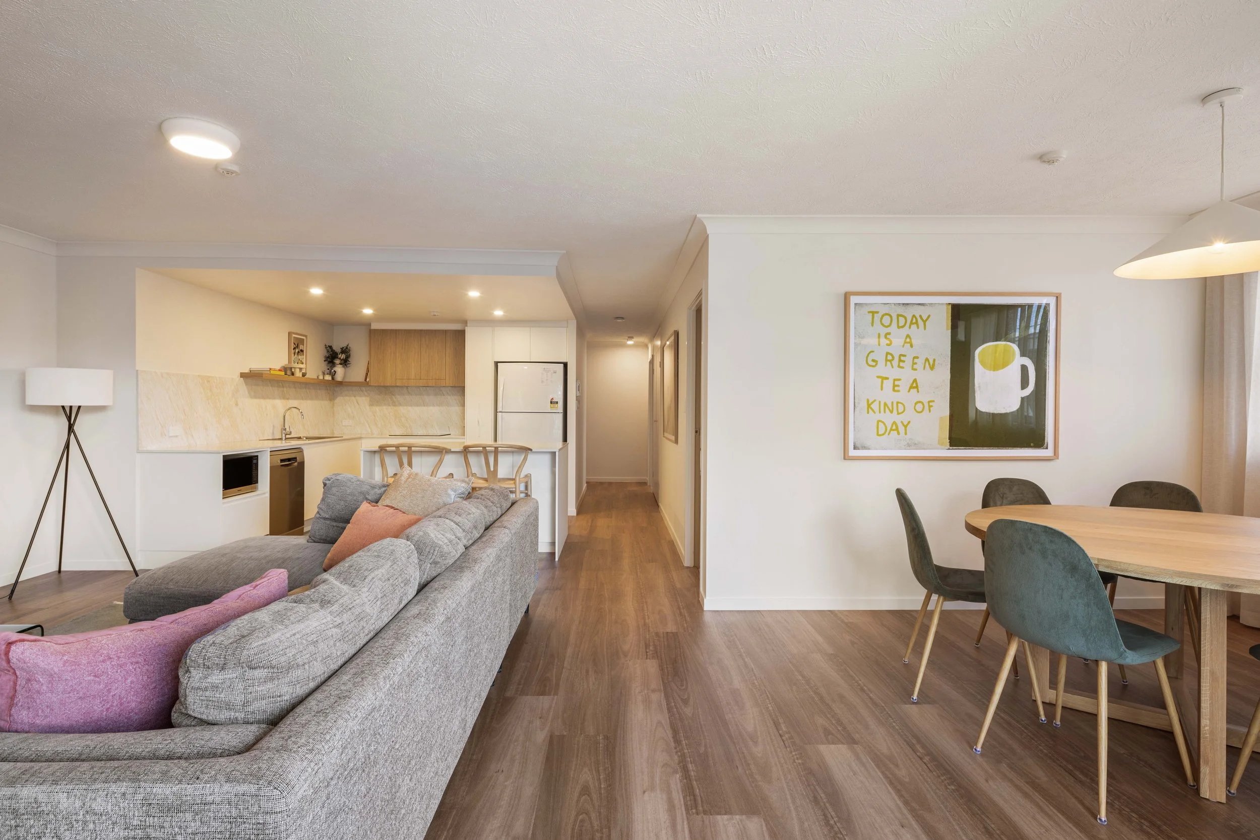 Open plan living utilising timber floors, white cabinets and walls, timeless and suitable for Airbnb and holidays on Gold Coast. 