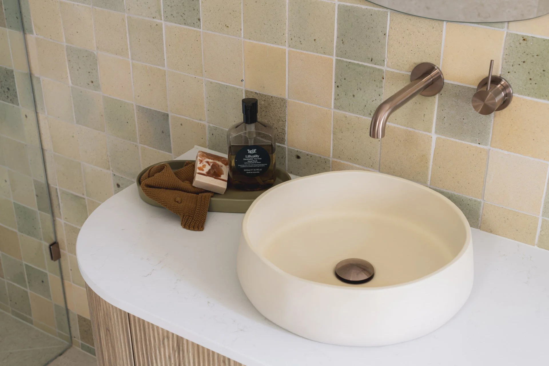 Earthy bathroom using handmade tiles, bronze tapware and nood co basin
