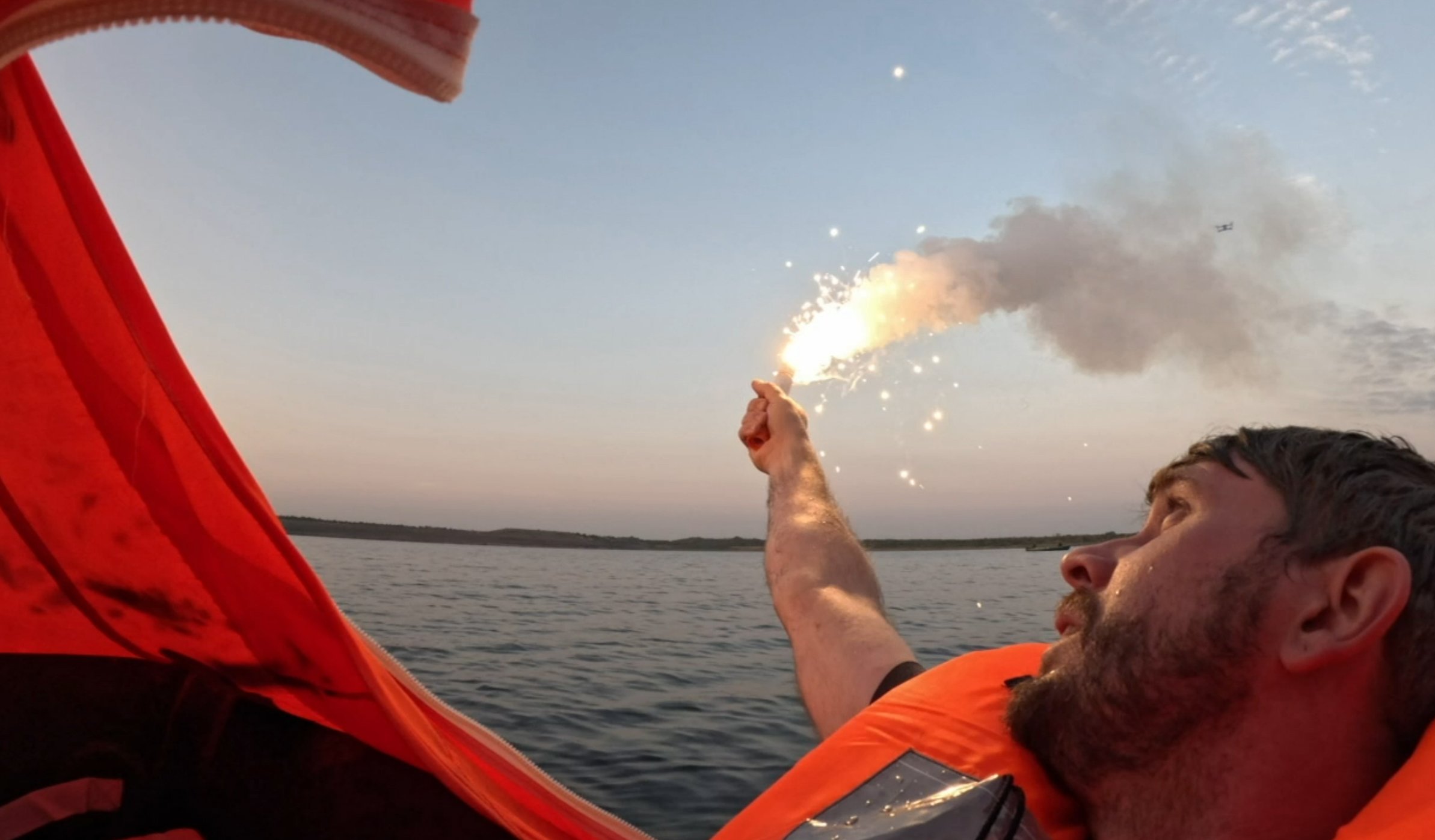 Mensch mit Rettungsmittel in einem Rettungsboot beim Coast Survival Training in Norwegen