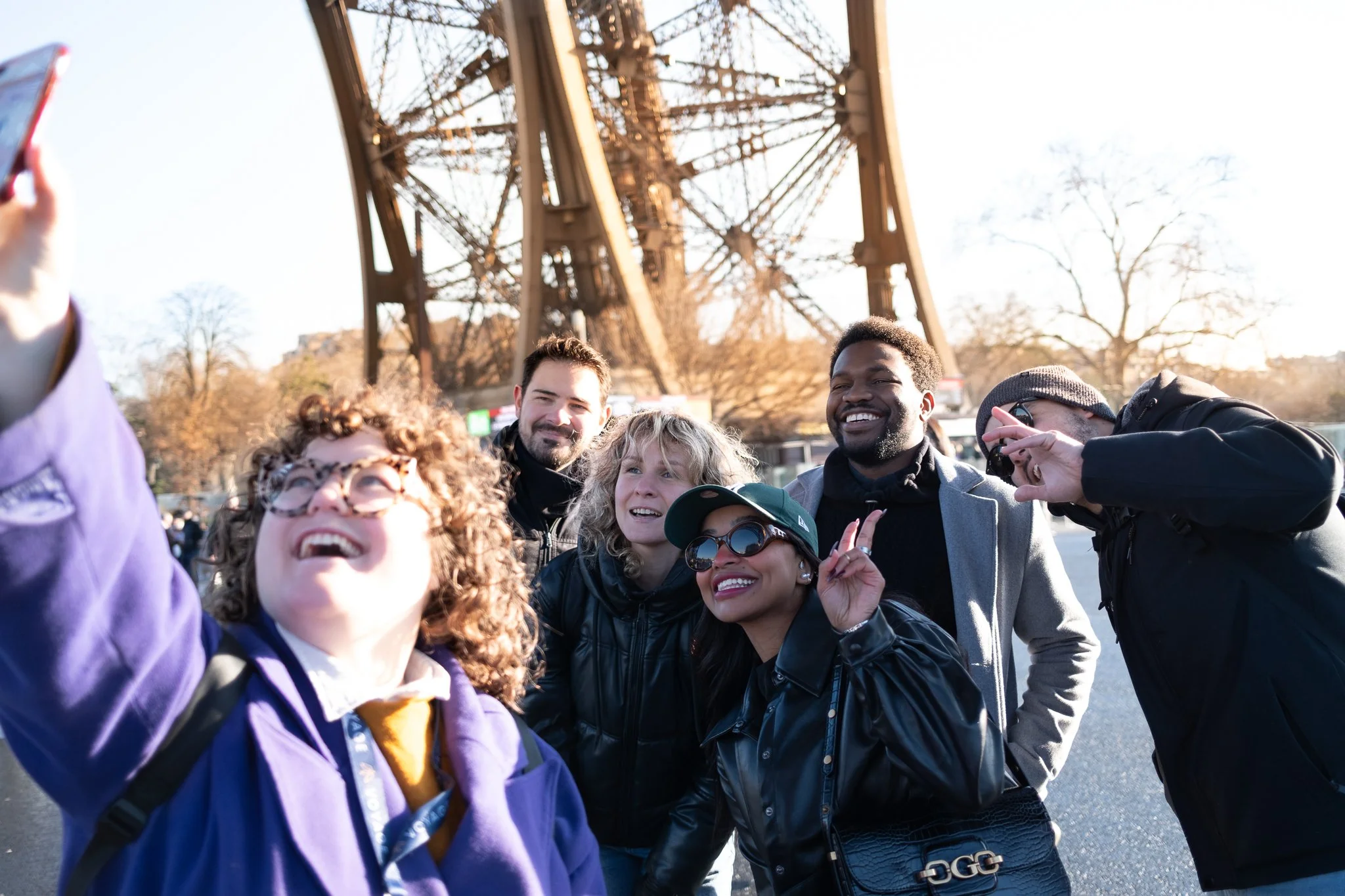 Group of people taking a selfie in front of the Eiffel Tower.