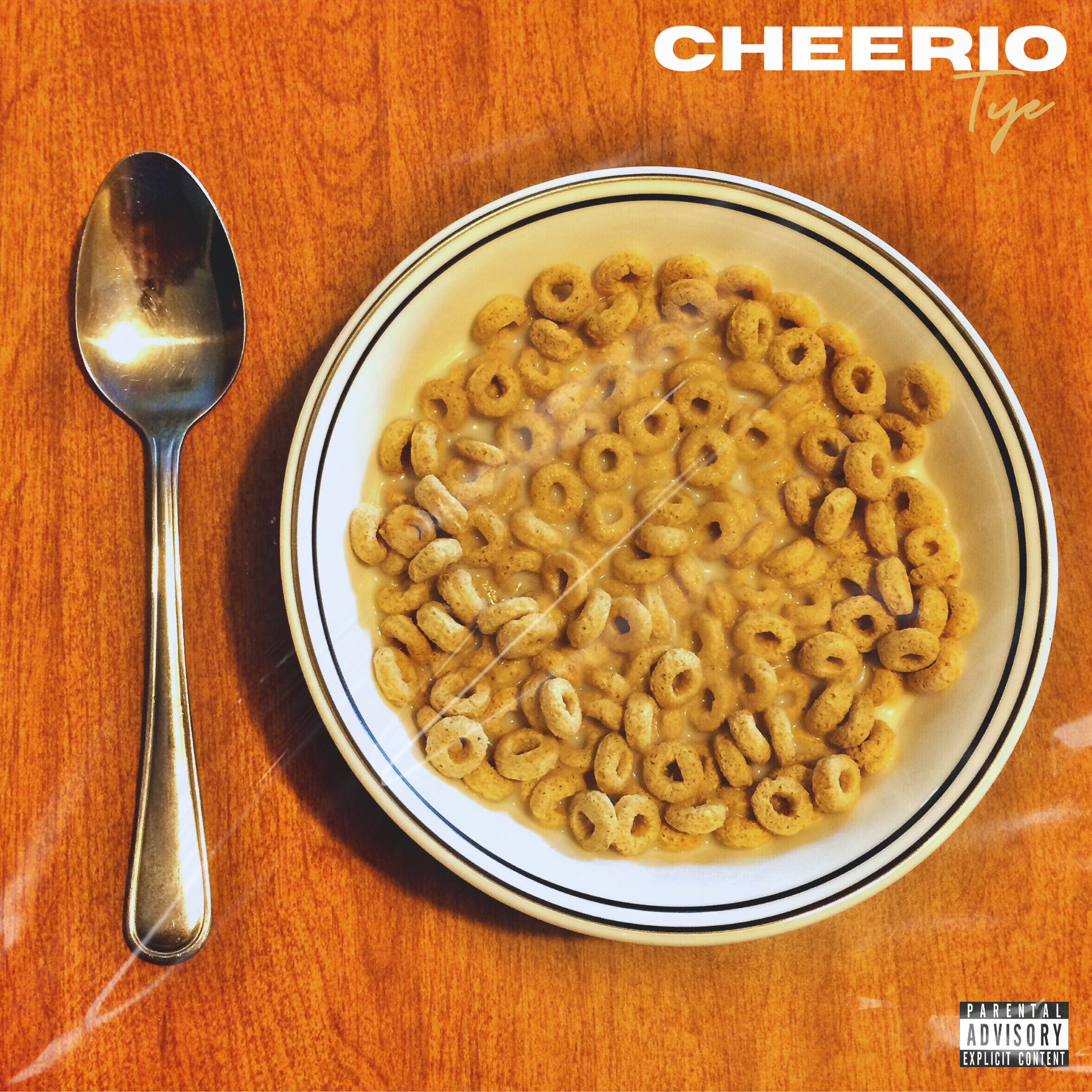 A bowl of Cheerios cereal with milk next to a spoon on a wooden table.