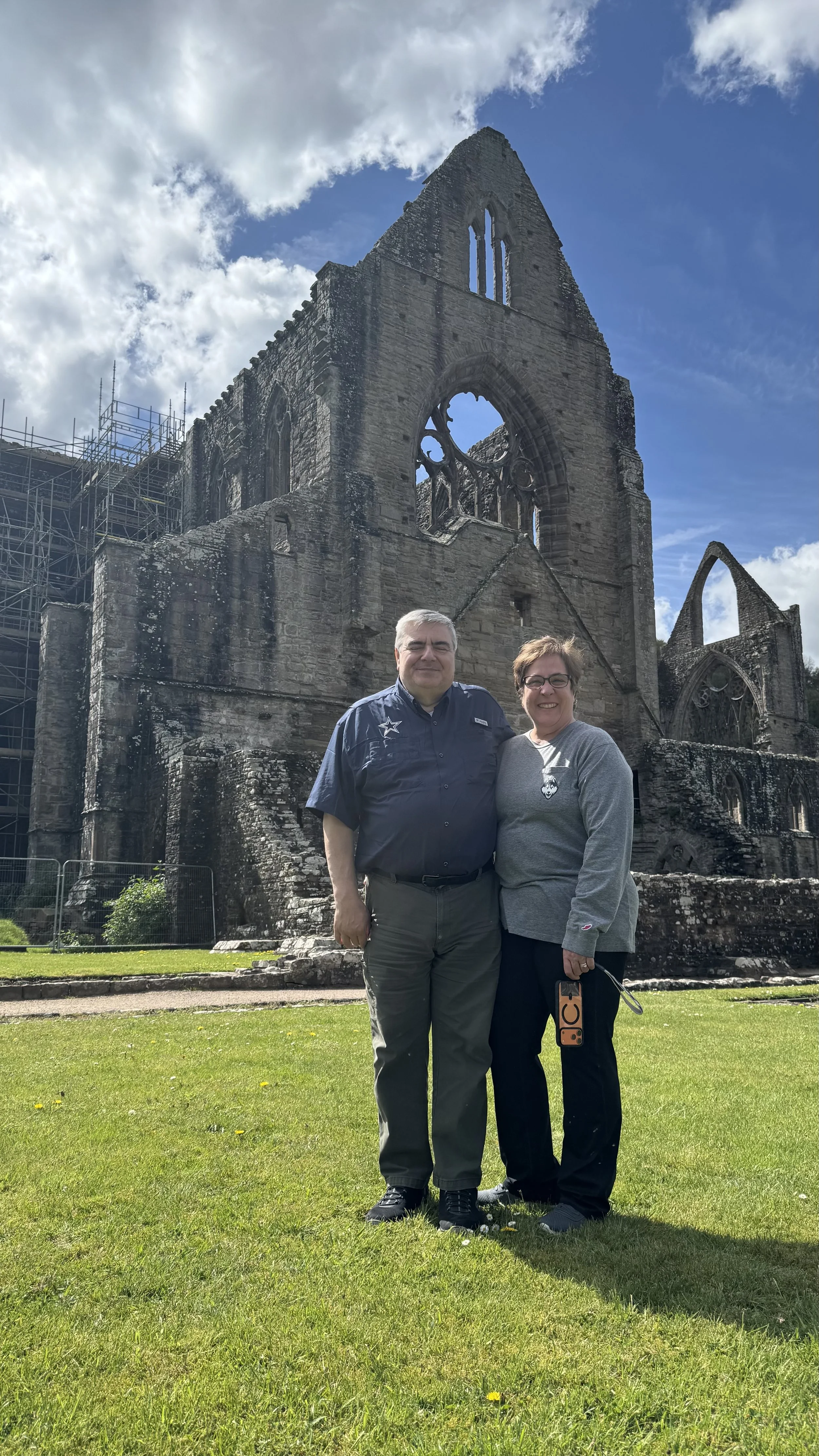  a couple posing for a photograph in front of Tintern Abbey 