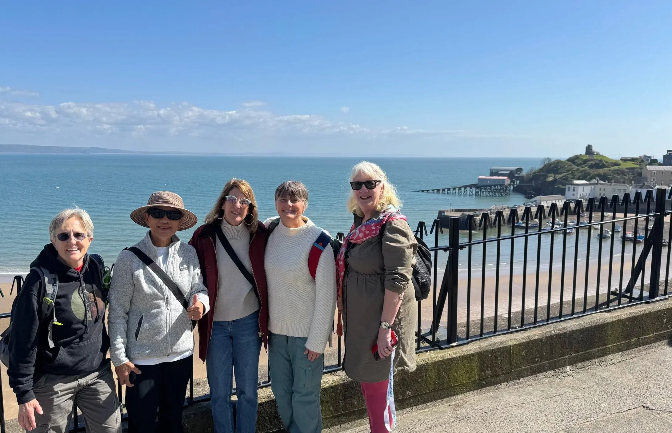  a group of holiday makers posing with Tenby Harbour in the background 