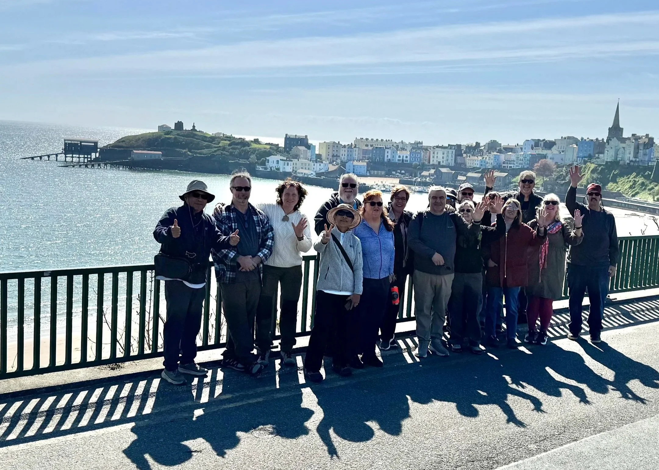  a group of holiday makers posing for a photograpgh with Tenby in the background 