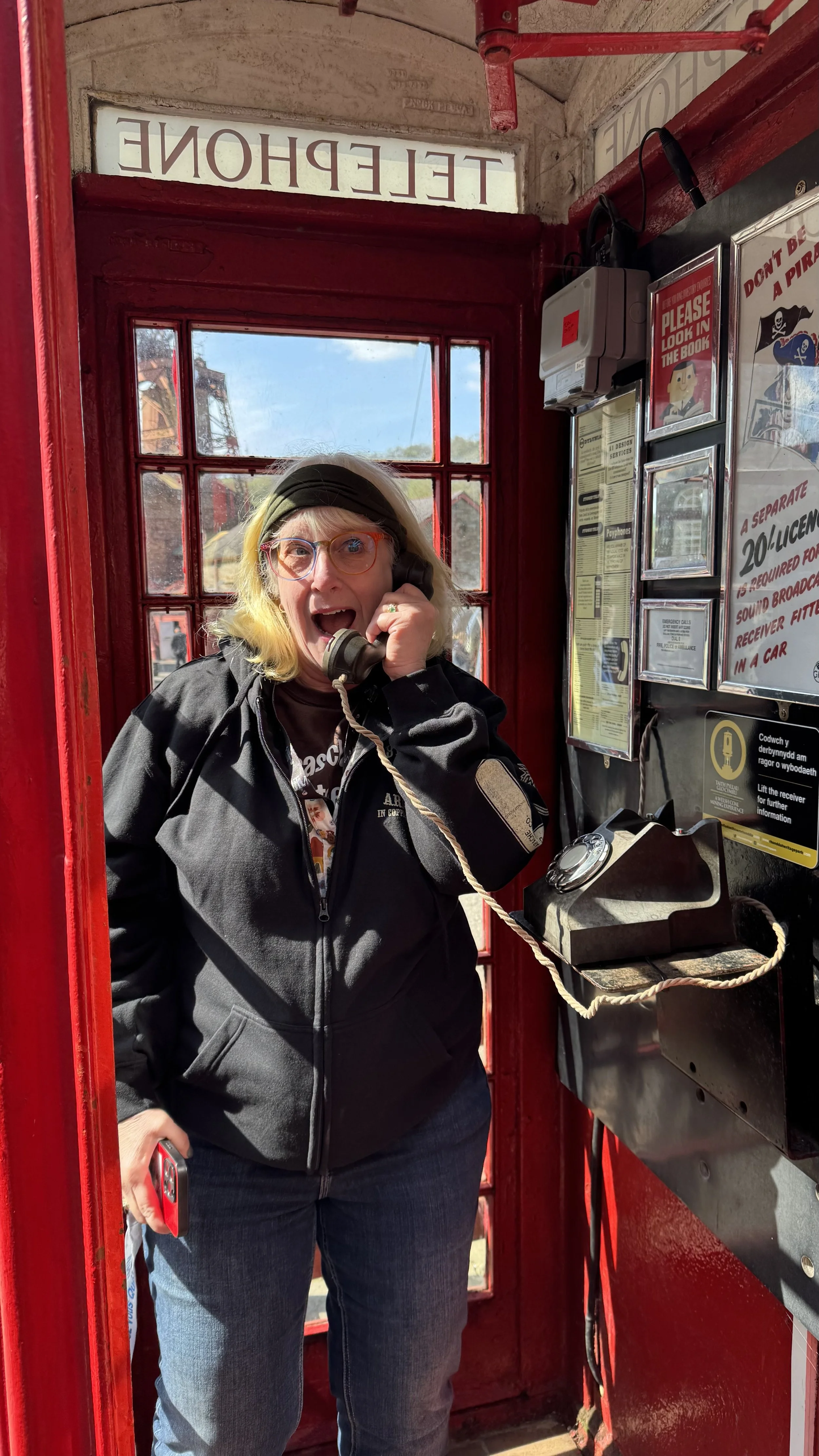  a holiday maker posing in a red telephone box 