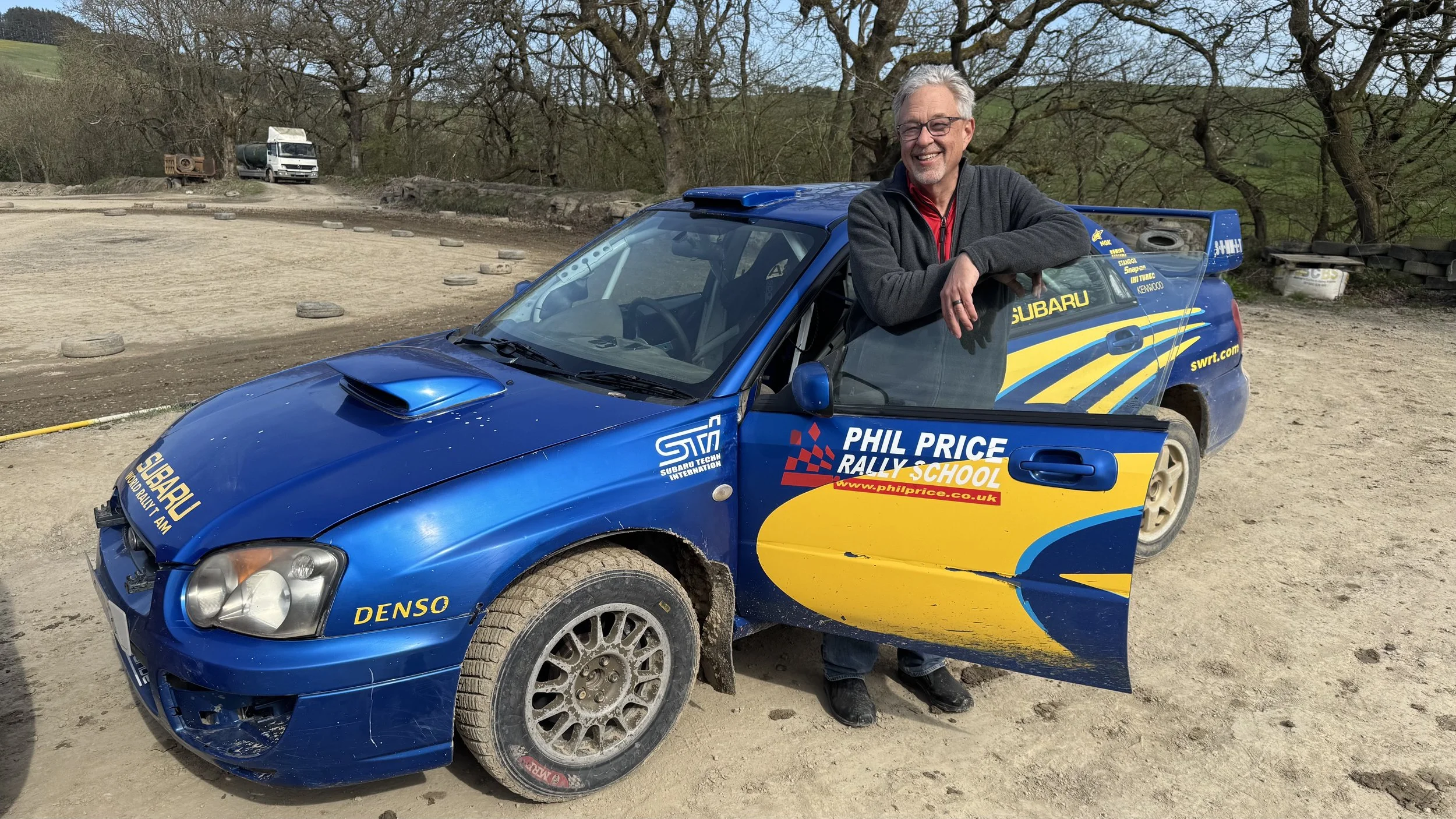  a holiday maker standing next to a rally car 