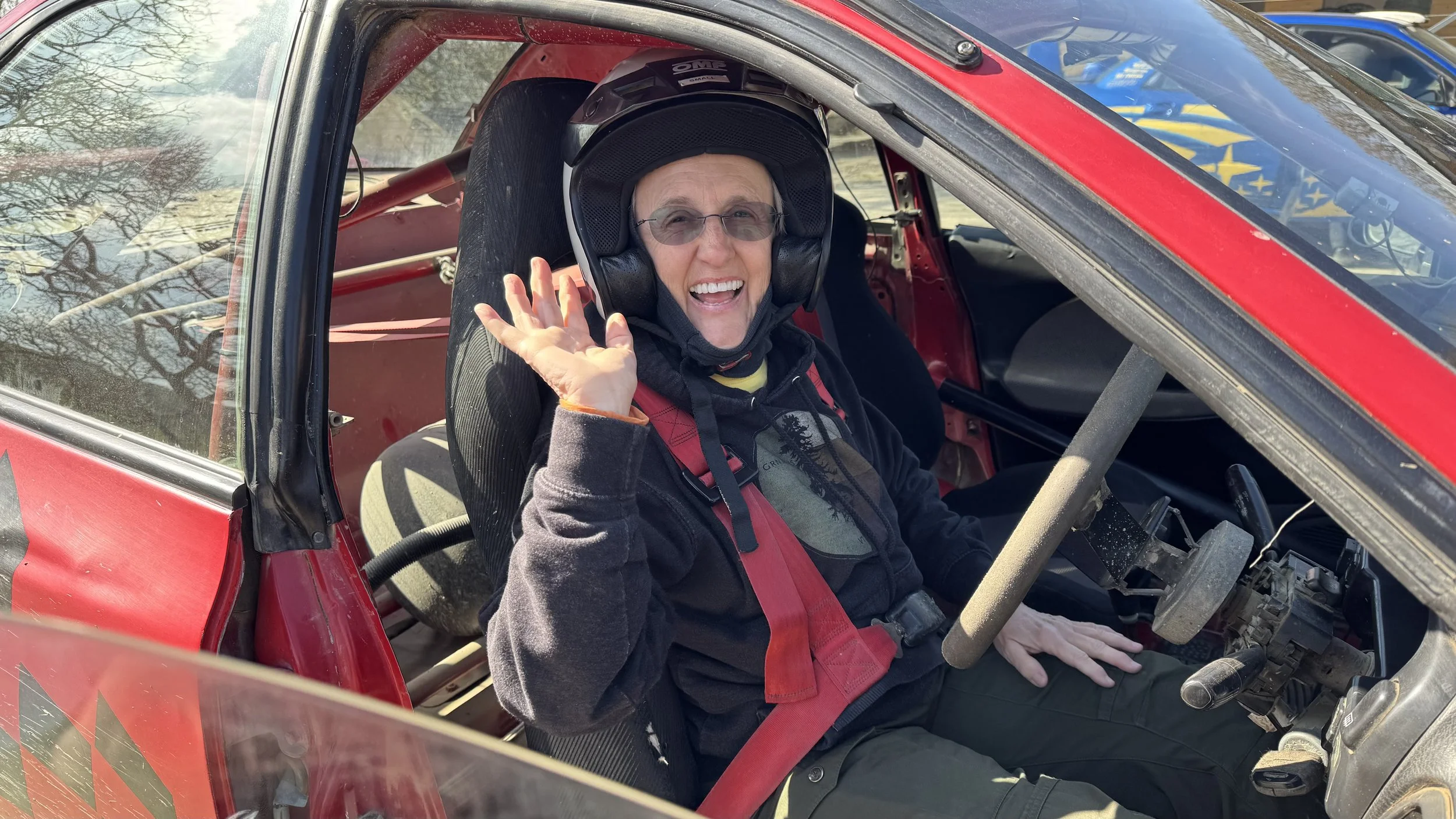  a holiday maker waving from a rally car 