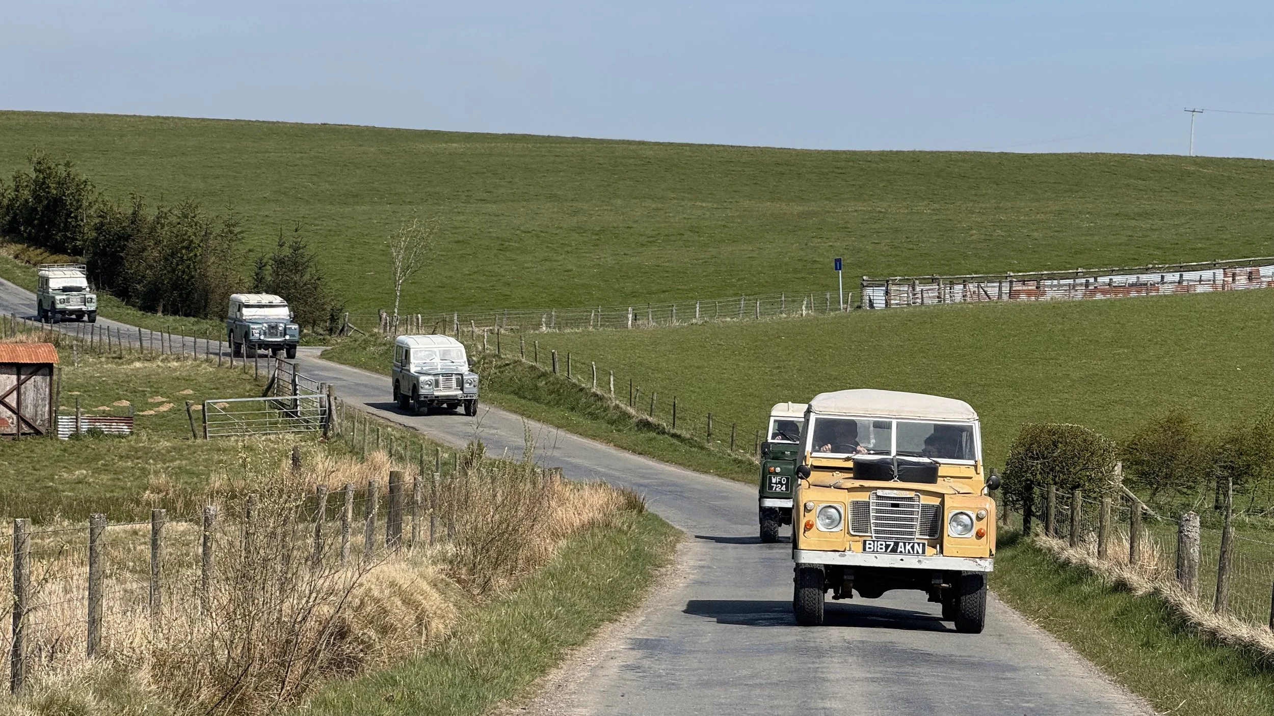  classic land rovers driving on country lanes 