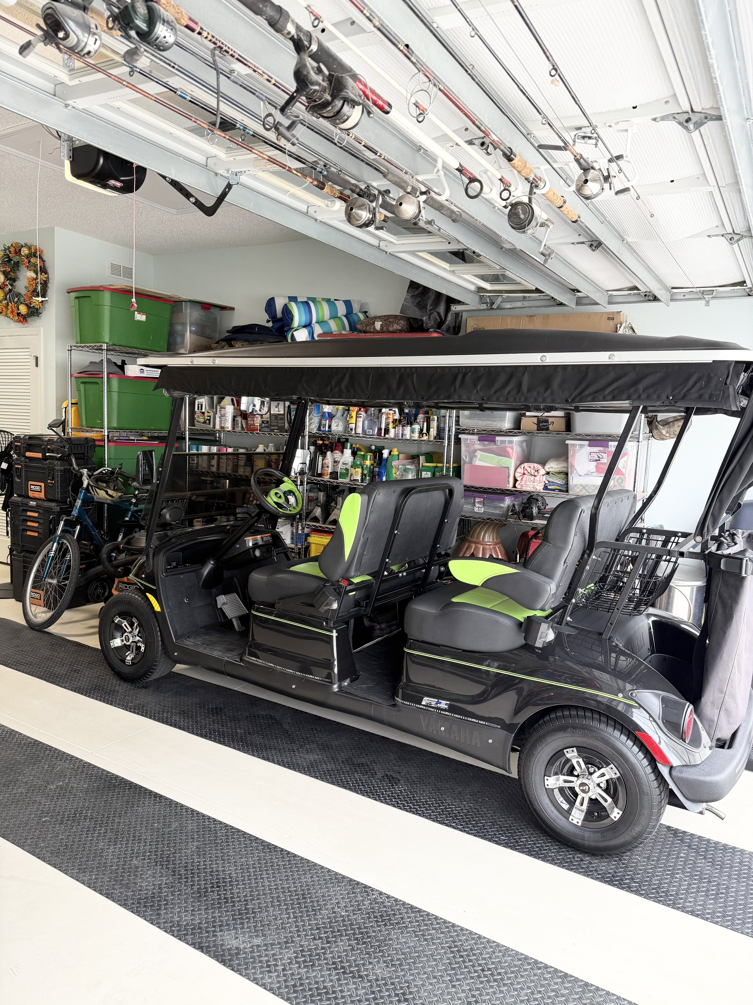 Garage interior with a golf cart and fishing rods.
