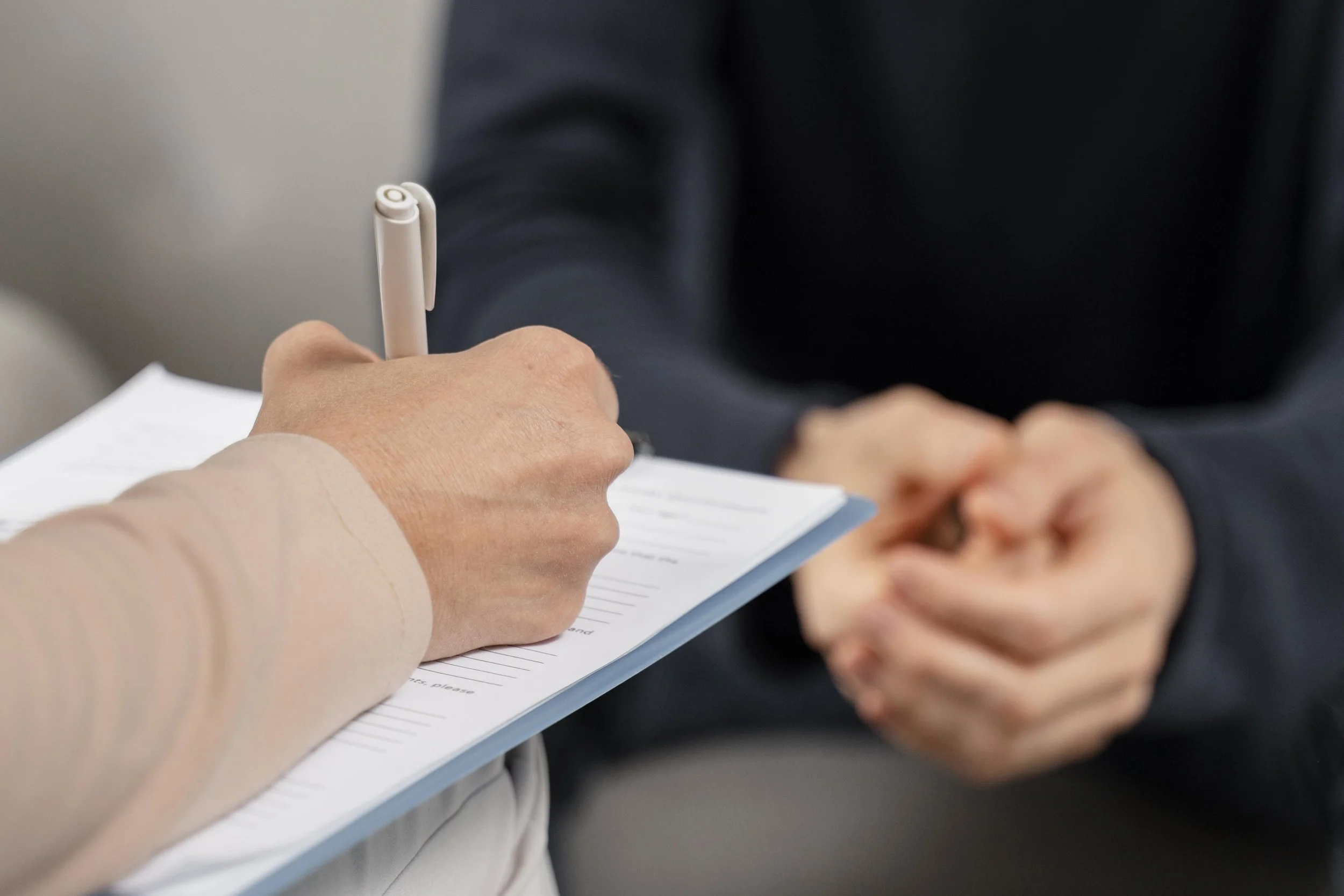 mid-shot-woman-therapist-taking-notes-clipboard.jpg
