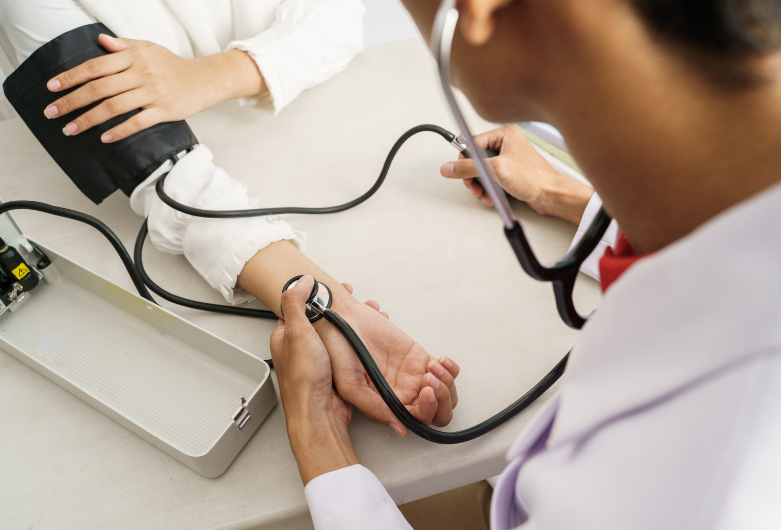 Doctor using a sphygmomanometer to check a patient's blood pressure.