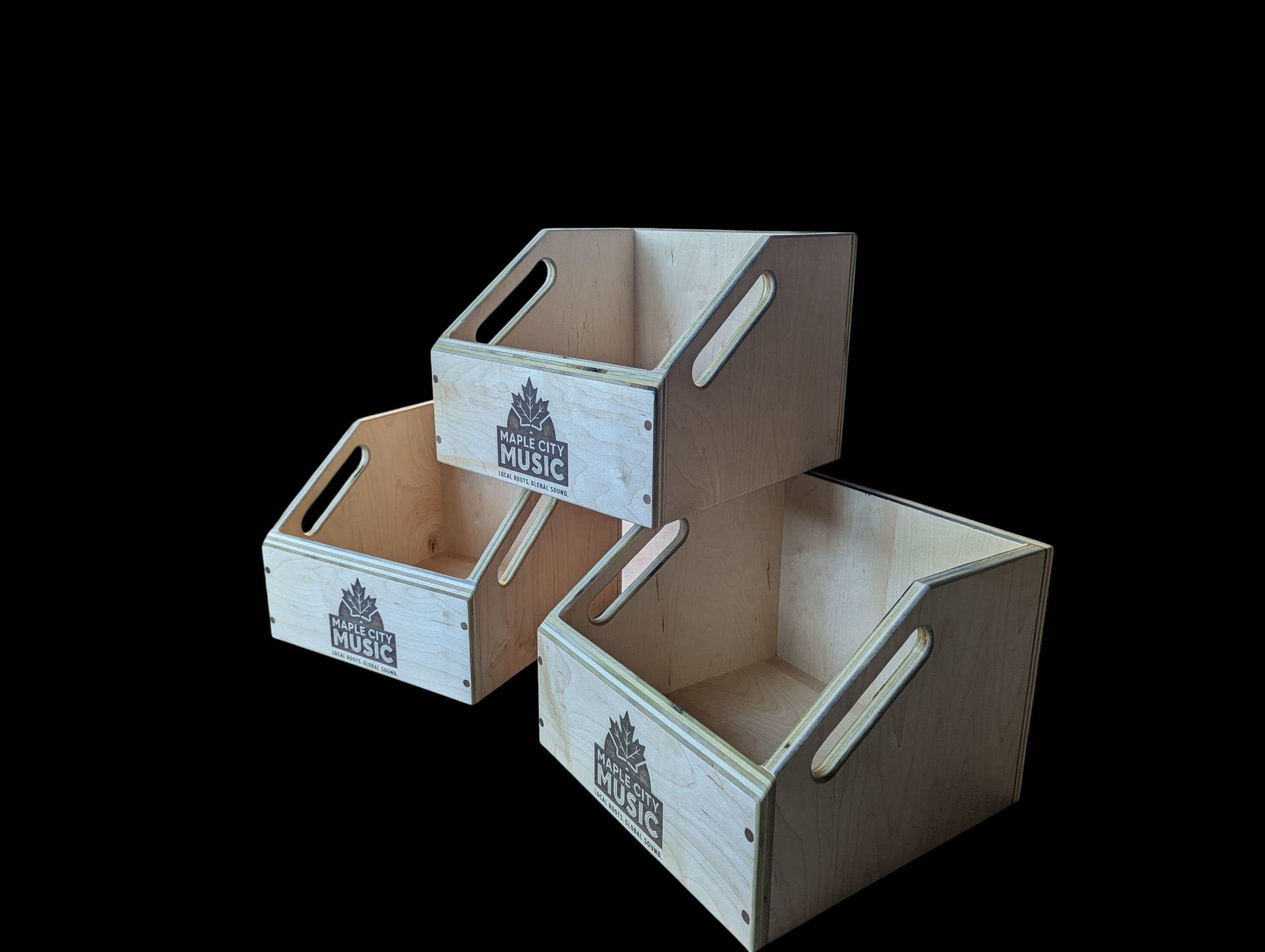 Three wooden crates with Maple City Music logos, arranged with one on top of two on a black background.