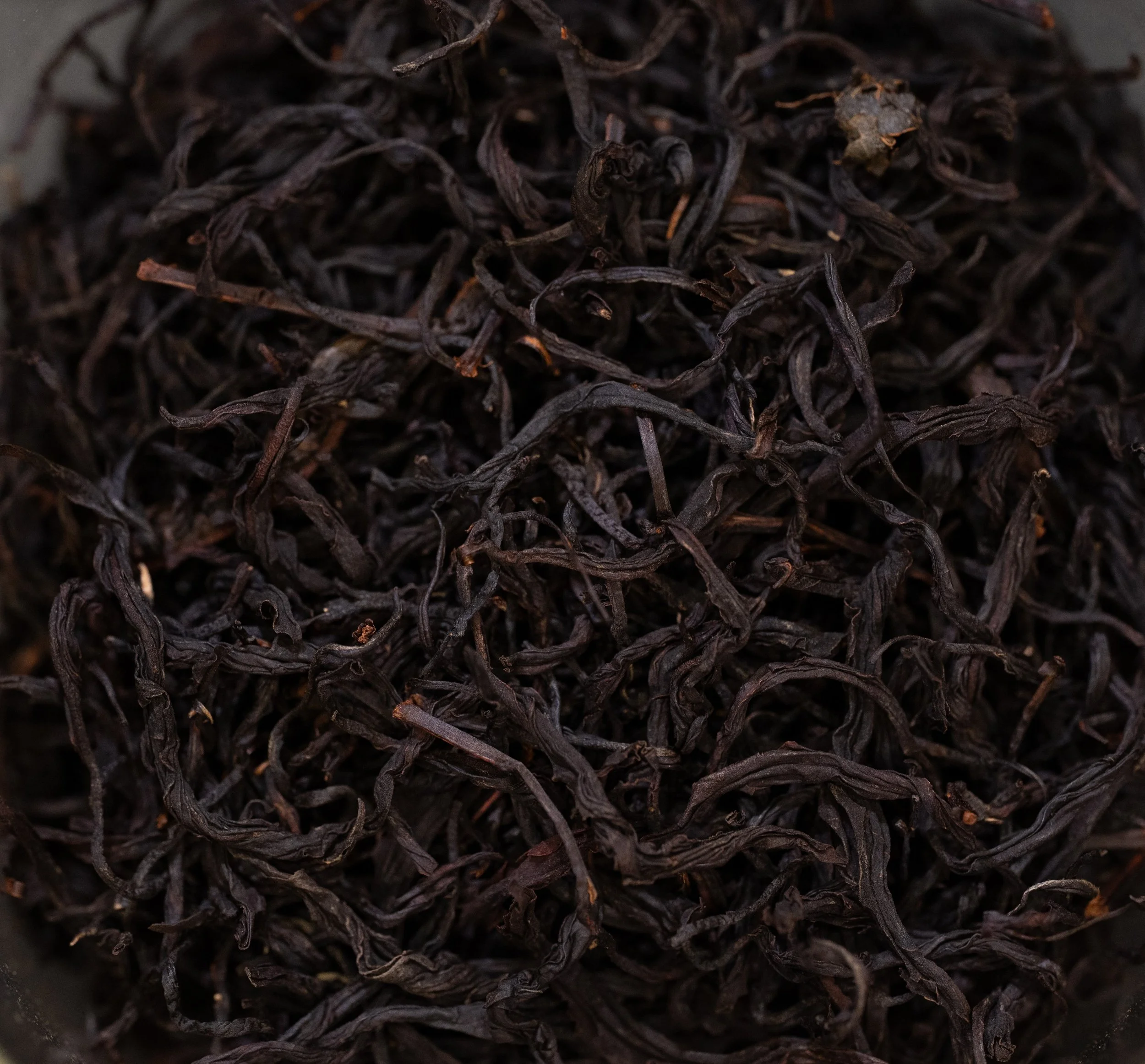 Close-up image of dried black tea leaves.