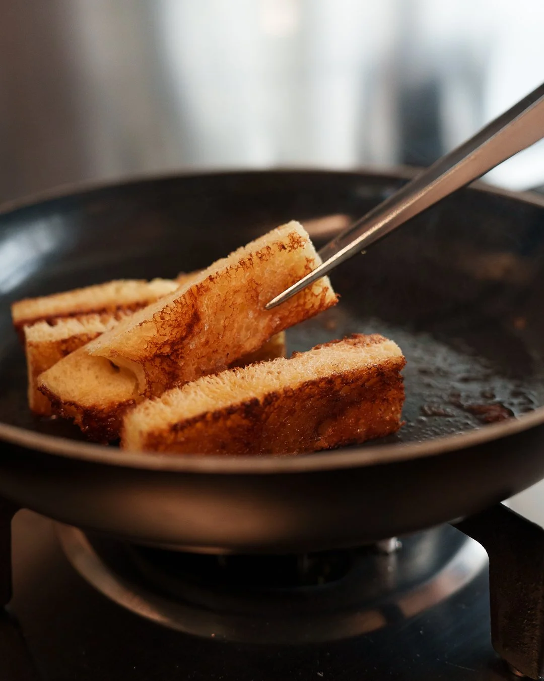 Close-up of bread slices being fried in a pan