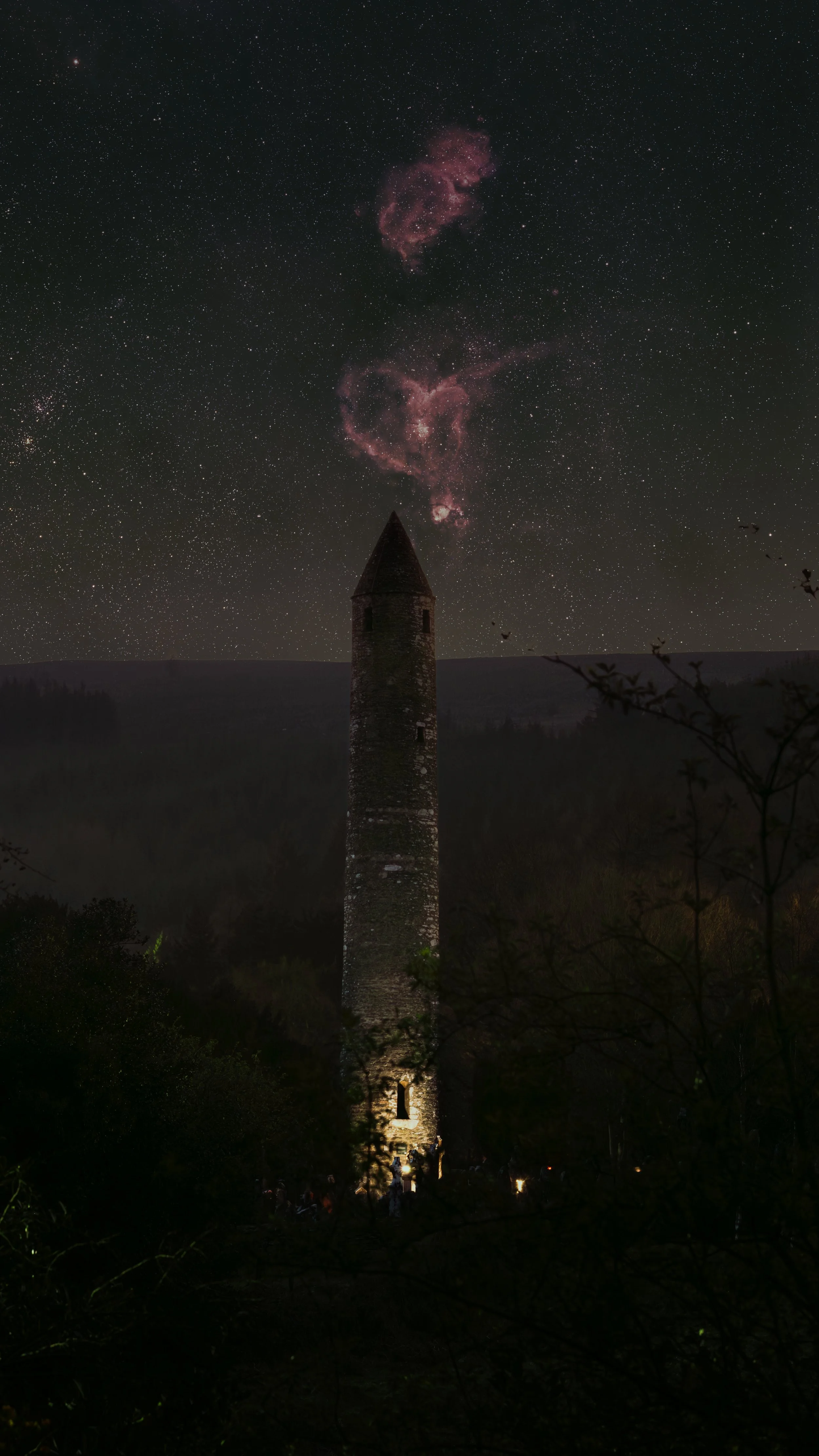 The round tower in the Glendalough graveyard with the heart and soul nebulae above