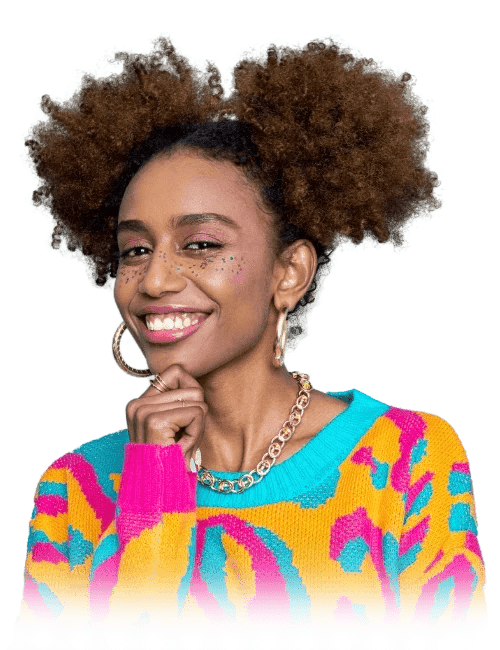 Smiling woman with natural curly hair, wearing colorful sweater and jewelry.