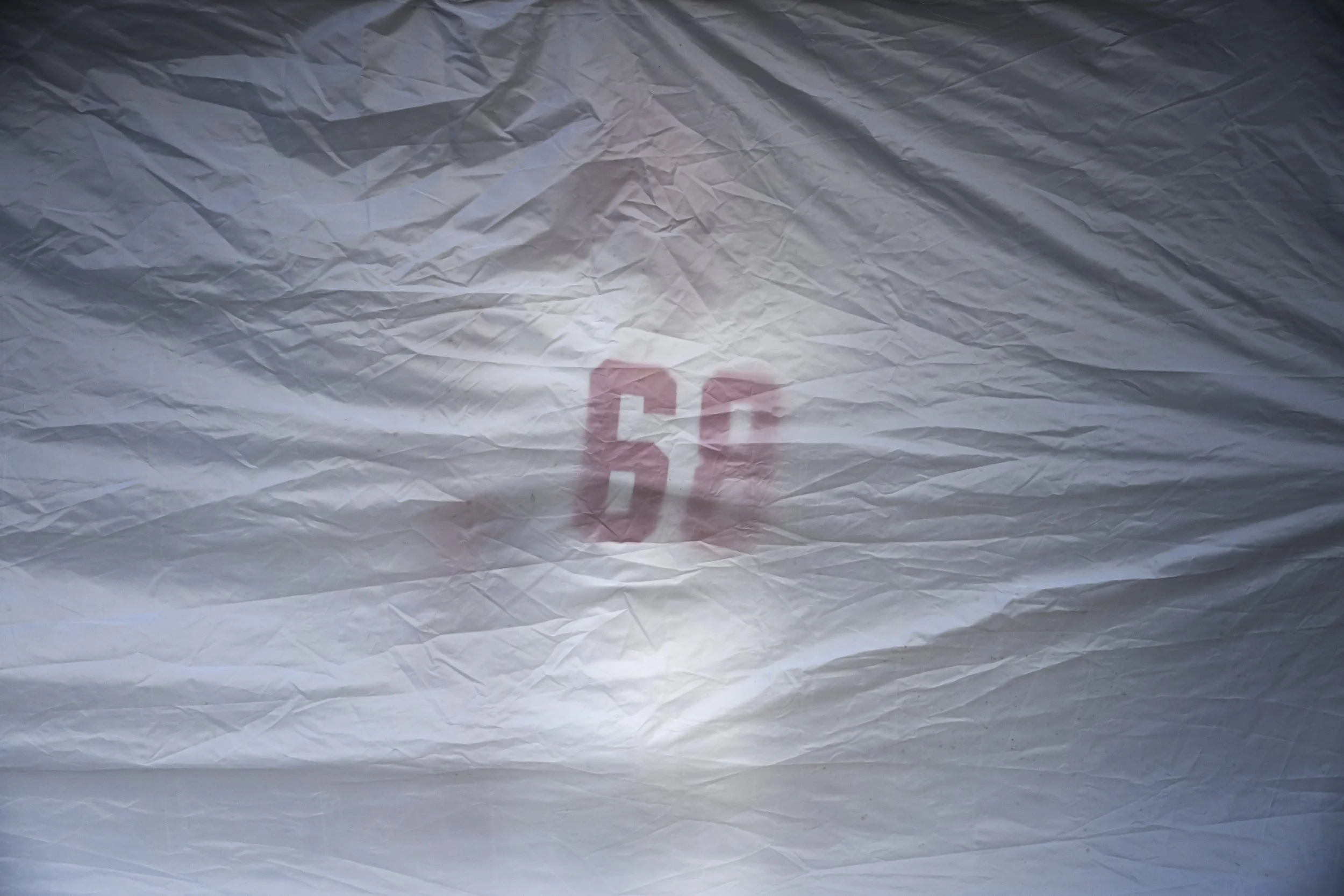 North Attleborough’s Trevor Oldmixon (68) stands near the wall of a plastic canopy where his team gathered before the Division 3 Milton vs. North Attleborough MIAA football semifinals at Milford High School in Milford, MA on Saturday, Nov. 22, 2025.