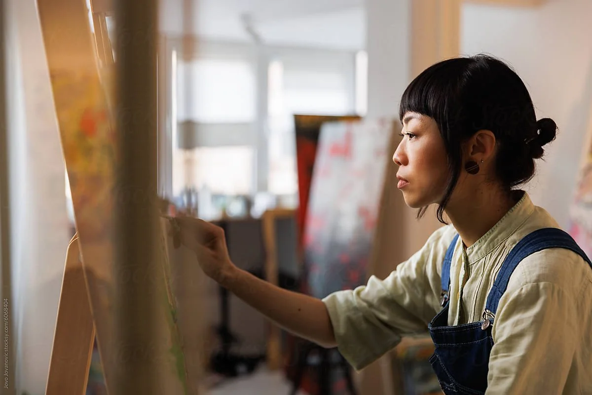 Feldenkrais client embodying poise in her painting process.