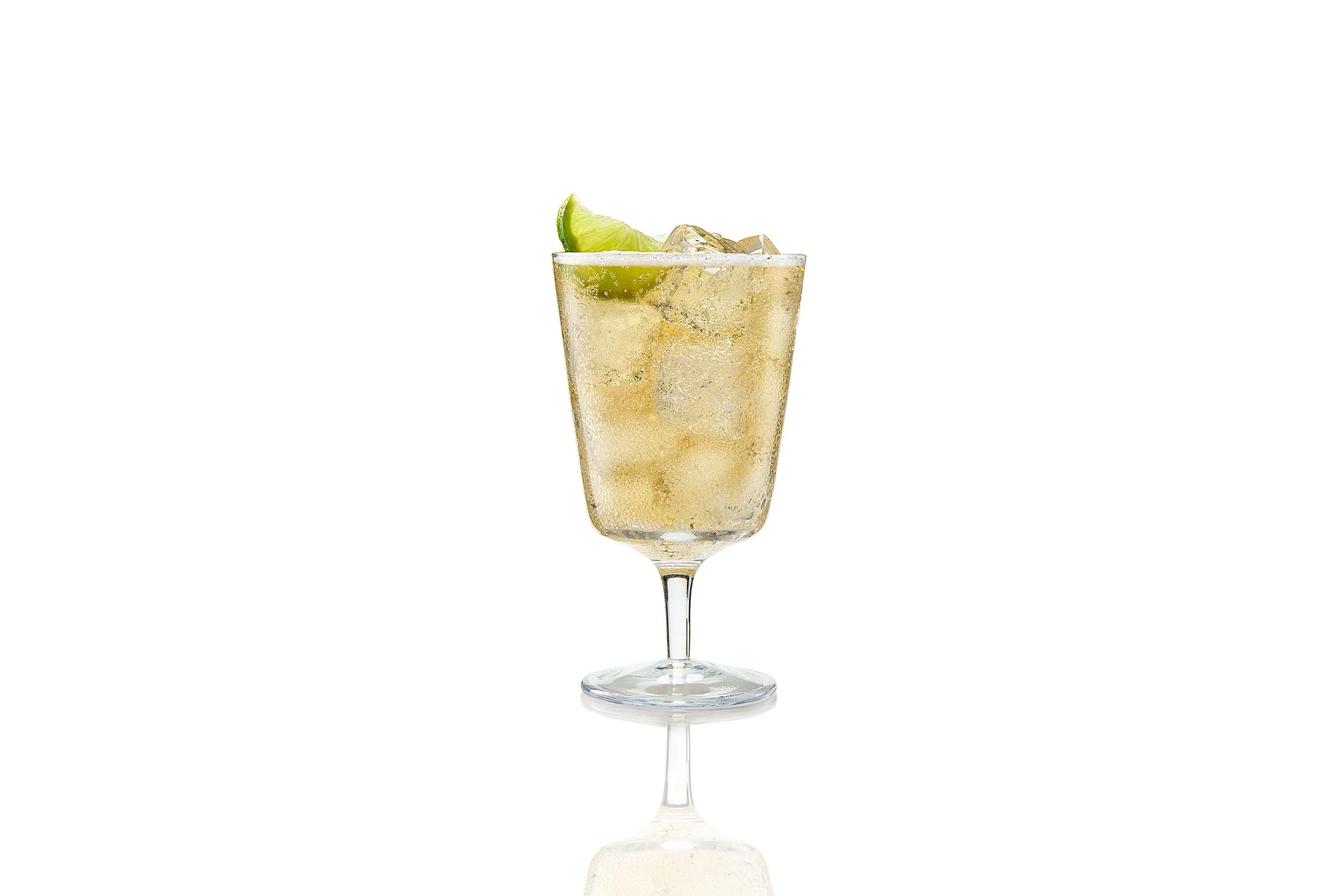 A glass of champagne with ice and a lime wedge garnishment.