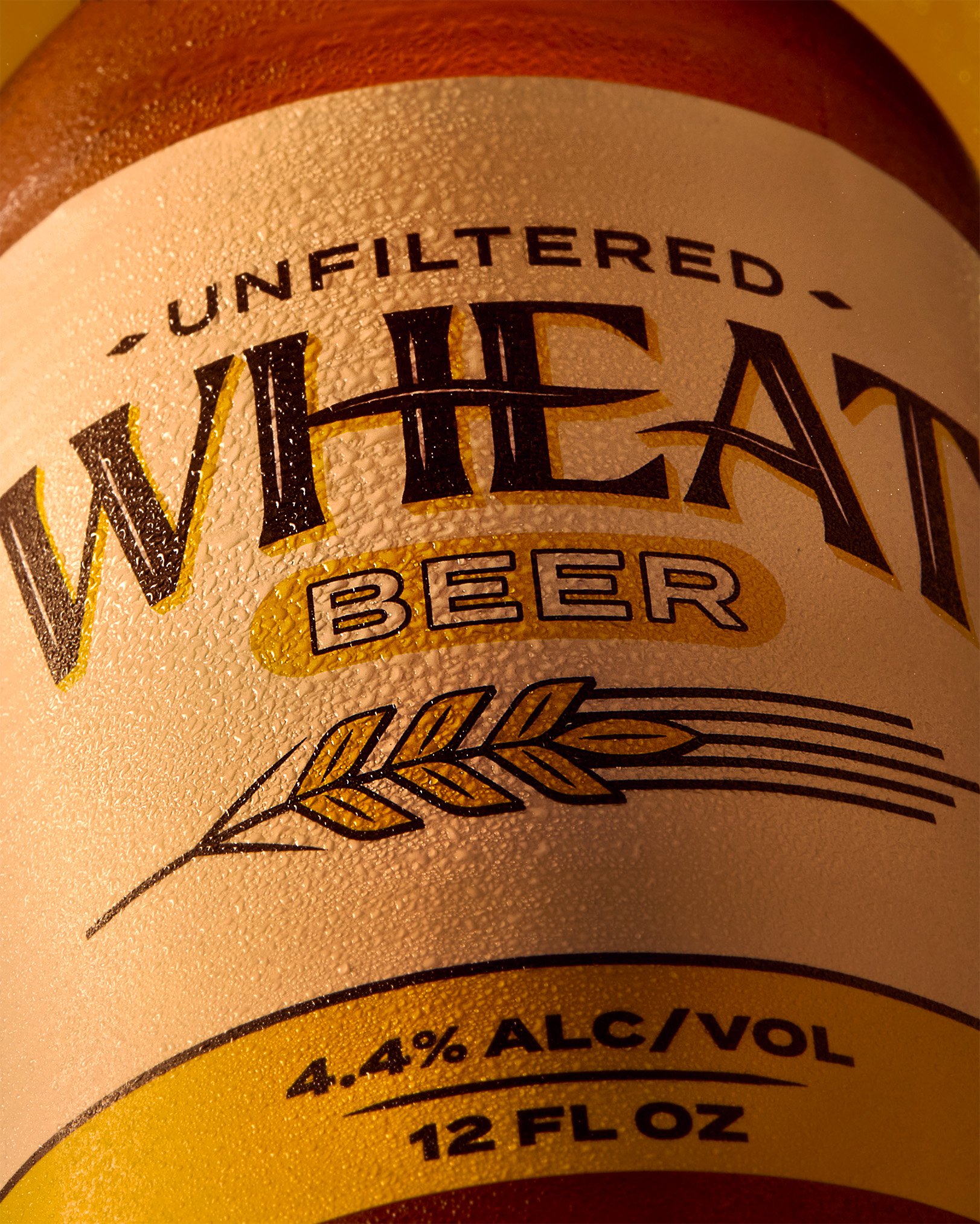 Close-up of a beer can label showing 'Wheat Beer' with alcohol content of 4.4%, size 12 fluid ounces, and 'Unfiltered' at the top.