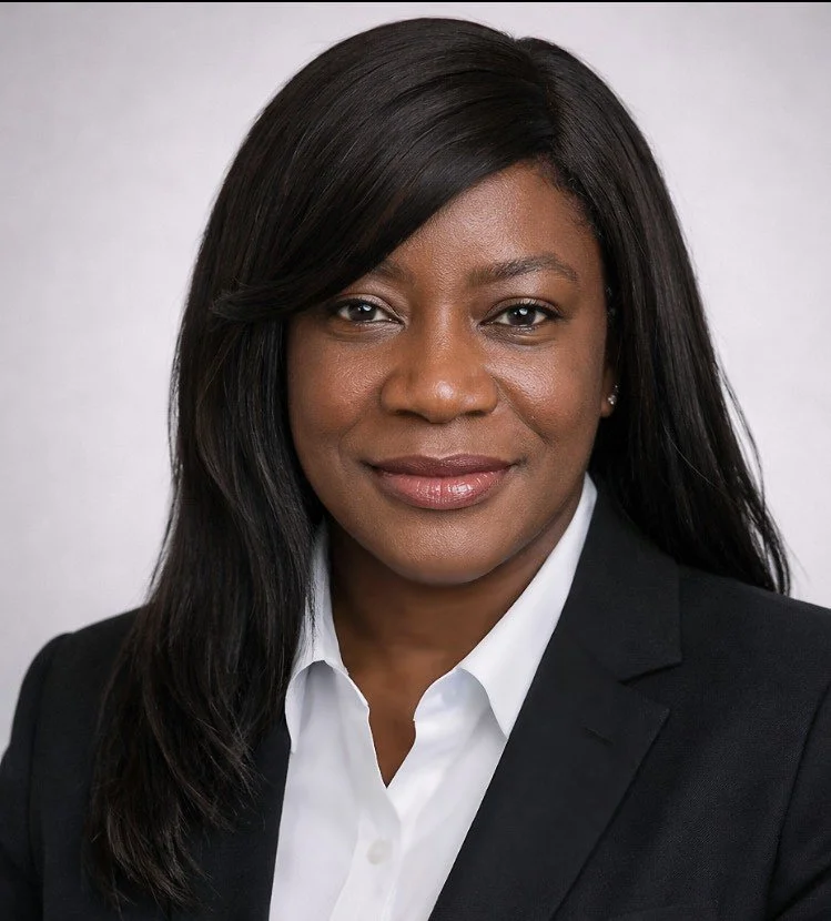 Close-up portrait of an African-American woman with shoulder-length wavy hair, wearing a black turtleneck and earrings, against a gray background.