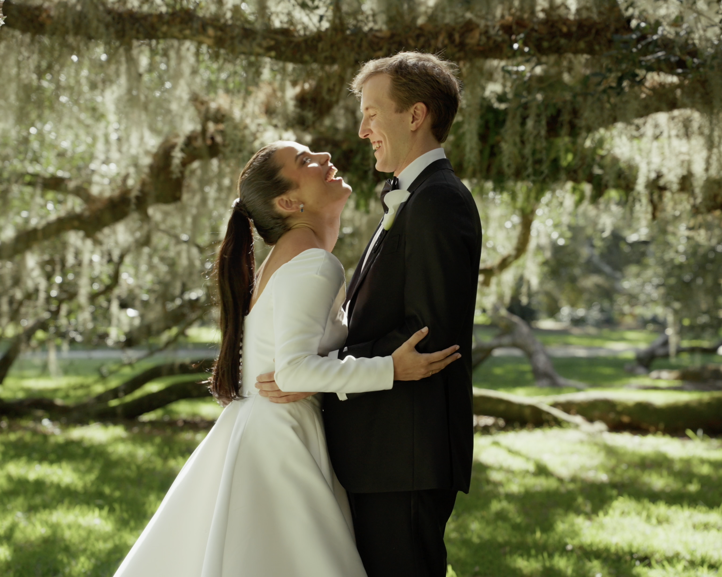 Wedding couple laughing together beneath Savannah oak trees