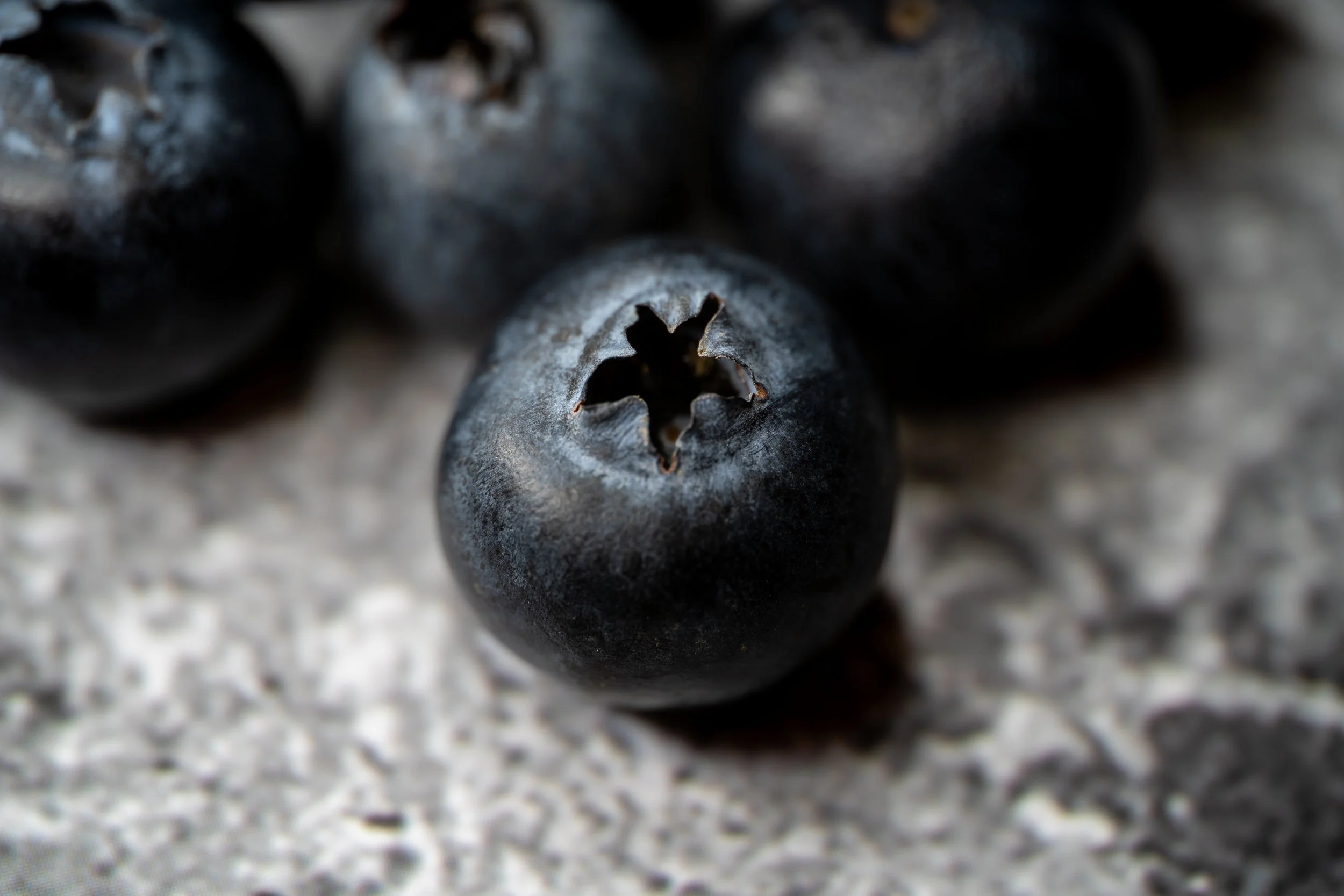 Close-up of fresh blueberries on a textured surface. Copyright Photography - Christoph Rutenkolk
