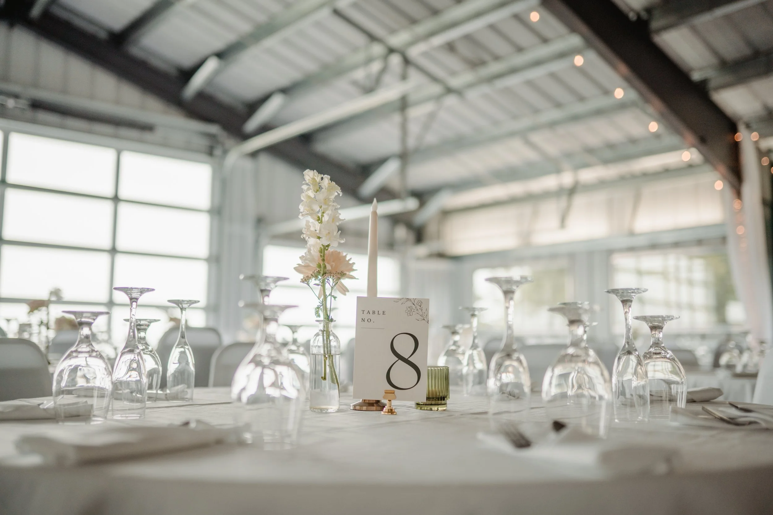 Wedding table scape featuring blush florals, candles, and glassware
