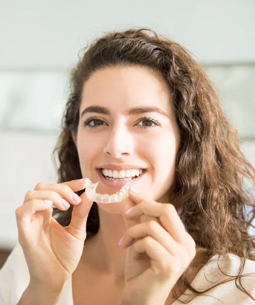 Adult holding a clear aligner