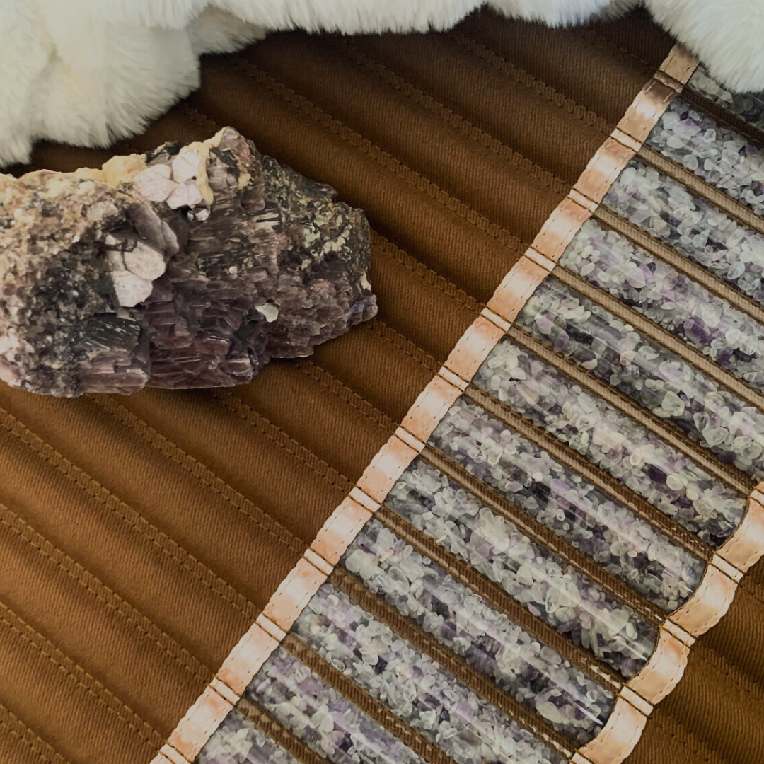 Close-up of the amethyst biomat, infrared therapy offered at inner Space in Des Moines, Iowa. Large amethyst crystal cluster is placed on top of the mat.