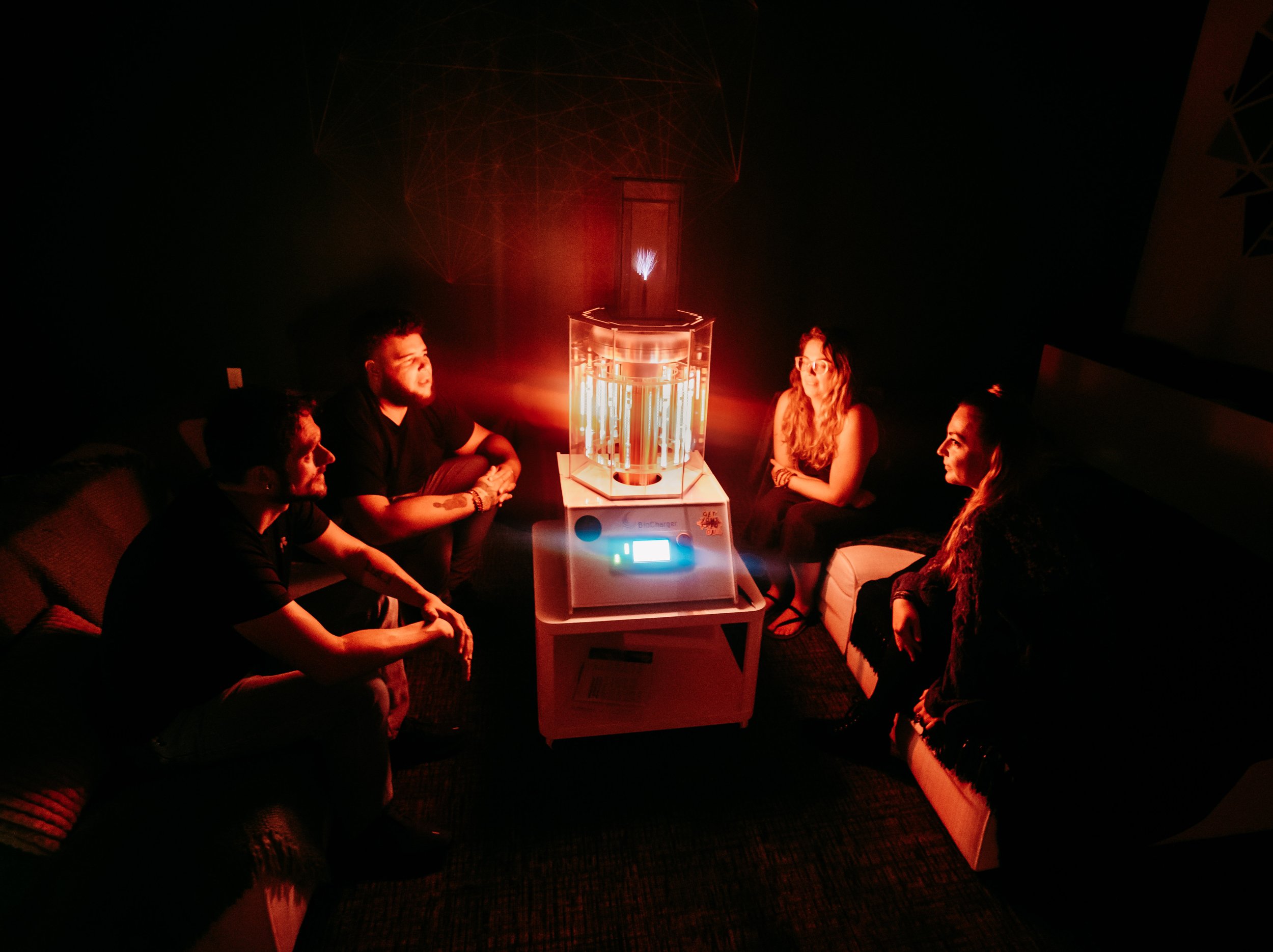 Group BioCharger frequency therapy session with four participants seated around the device at Inner Space supporting energy and nervous system regulation.