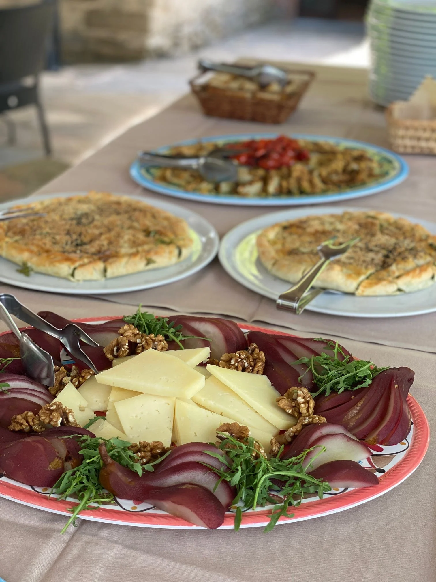 A plate of sliced beets with cheese, walnuts, and greens on a decorative serving platter.