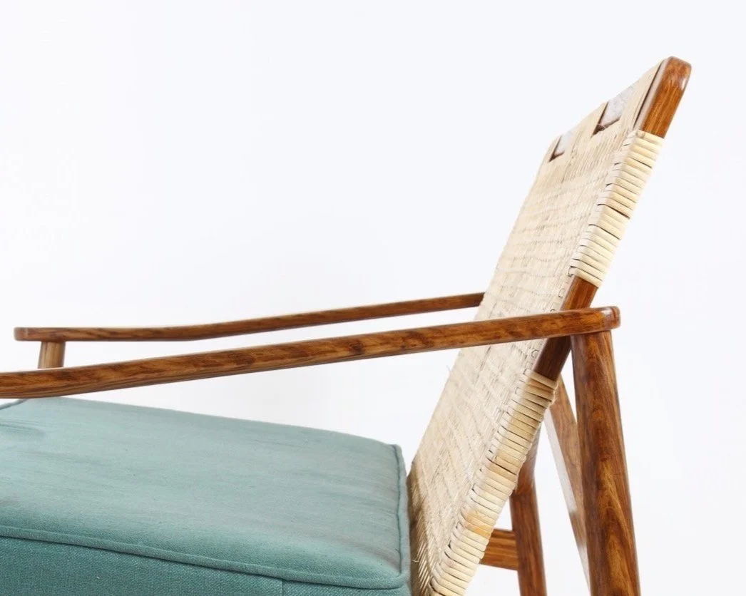 Mid-century inspired two seat sofa in brown oak. Handwoven rattan backrest, hand-sculpted arms, turned leg and bespoke linen cushion