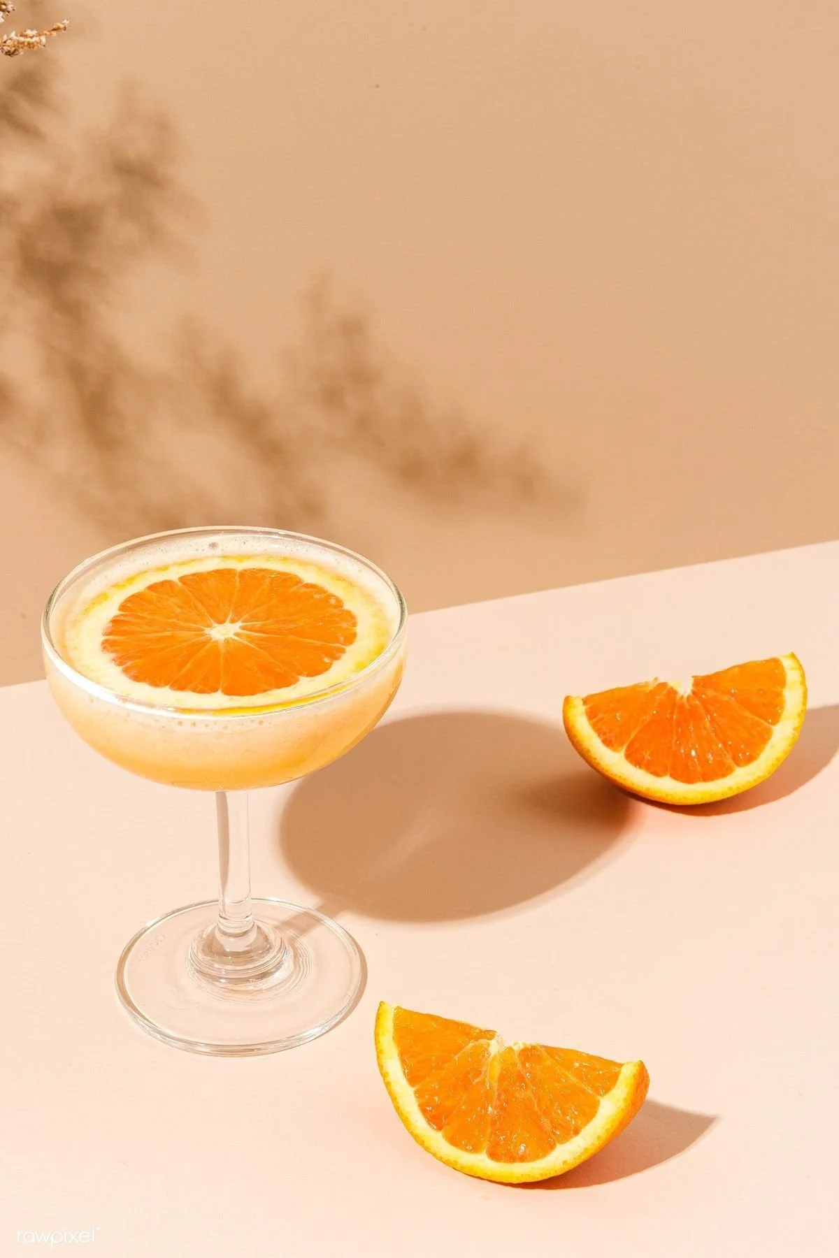 Stacked champagne glasses filled with rosé wine, outdoors against a clear blue sky.