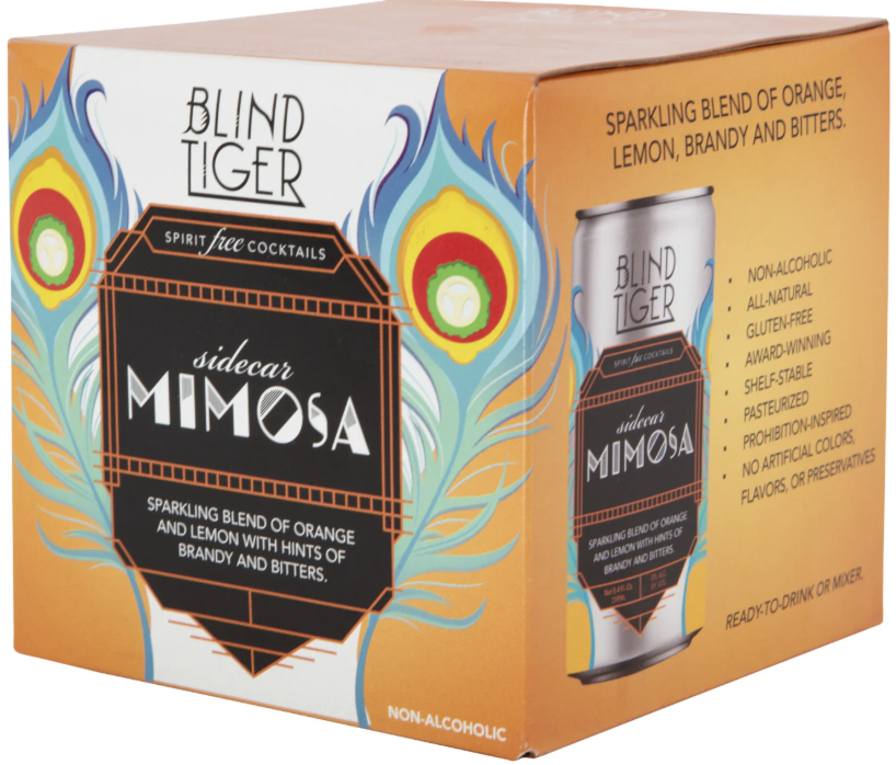 Box of Blind Tiger Sidecar Mimosa cocktail mix with a peacock feather design and a silver can illustration. The box describes it as a non-alcoholic, all-natural, gluten-free, award-winning, pasteurized, prohibition-inspired drink with no artificial colors, flavors, or preservatives, ready to drink or mix.
